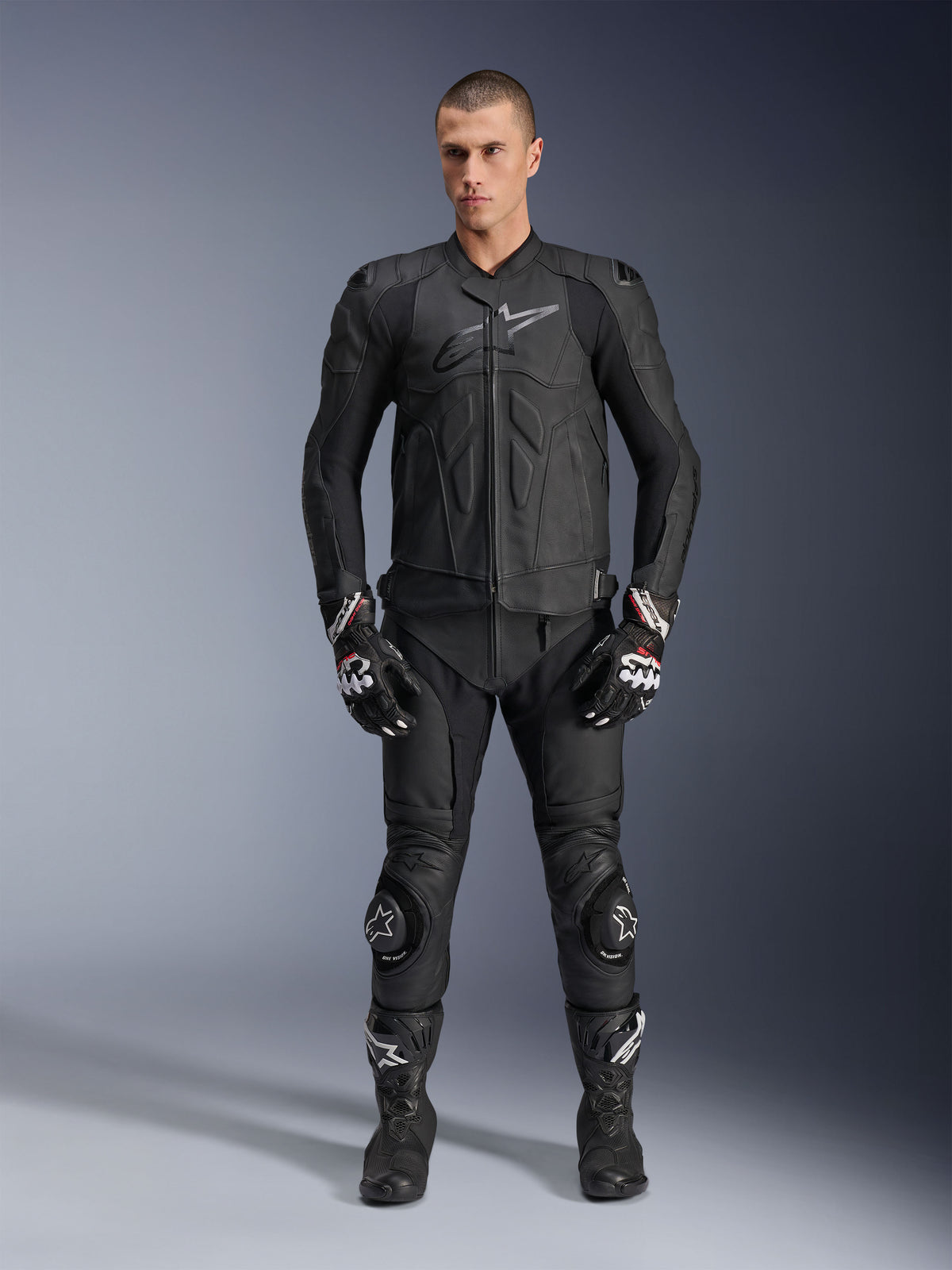 Alpinestars giacca in pelle Dusk, giacca da moto sportiva nera in pelle bovina, indossata da un modello in completo racing.