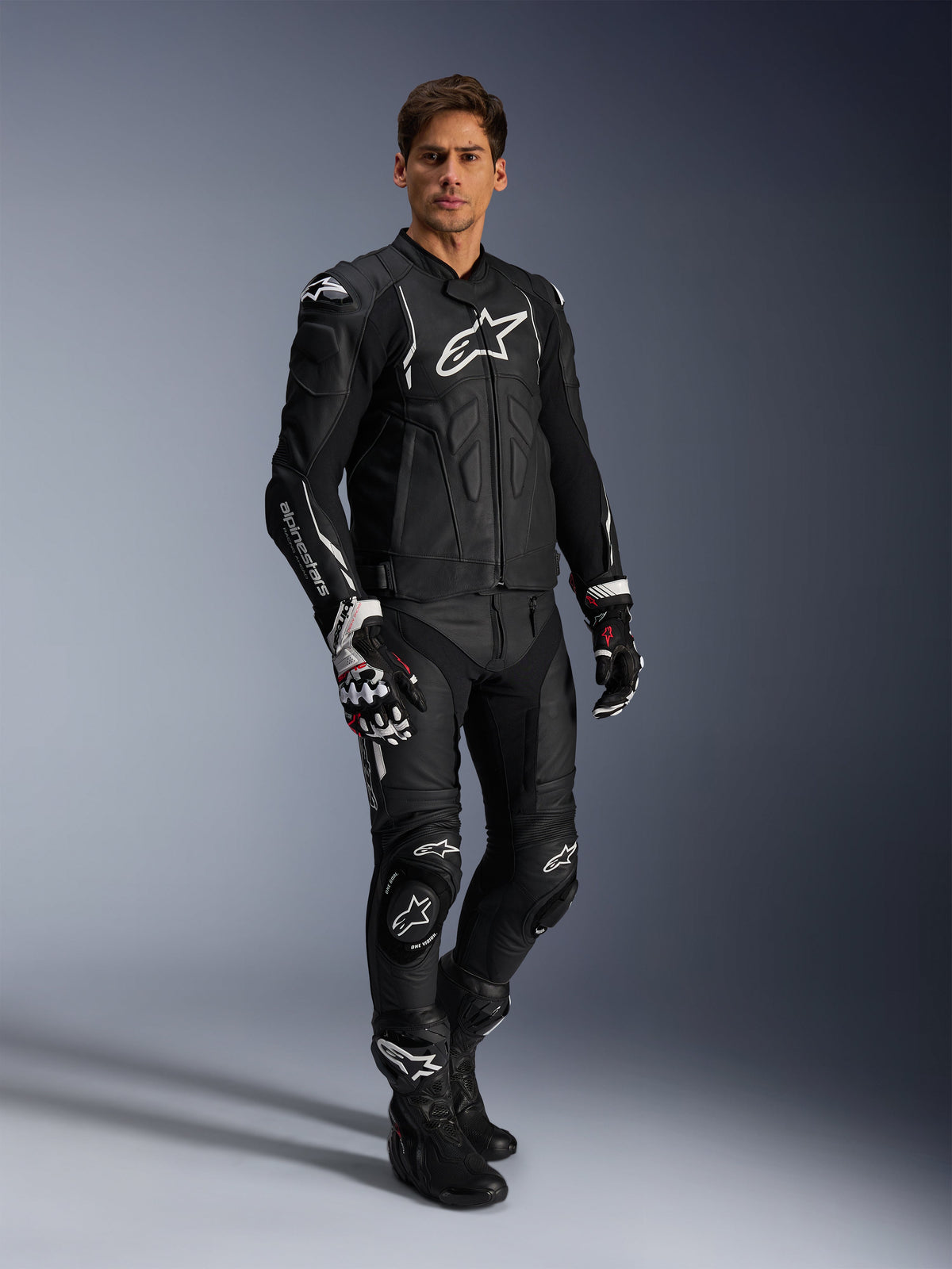 Pantaloni in pelle Alpinestars Missile V3 e giacca in pelle nera coordinata, tuta da moto completa, nera con logo Alpinestars bianco su petto e ginocchia, include guanti e stivali racing professionali, equipaggiamento protettivo aerodinamico per strada e pista