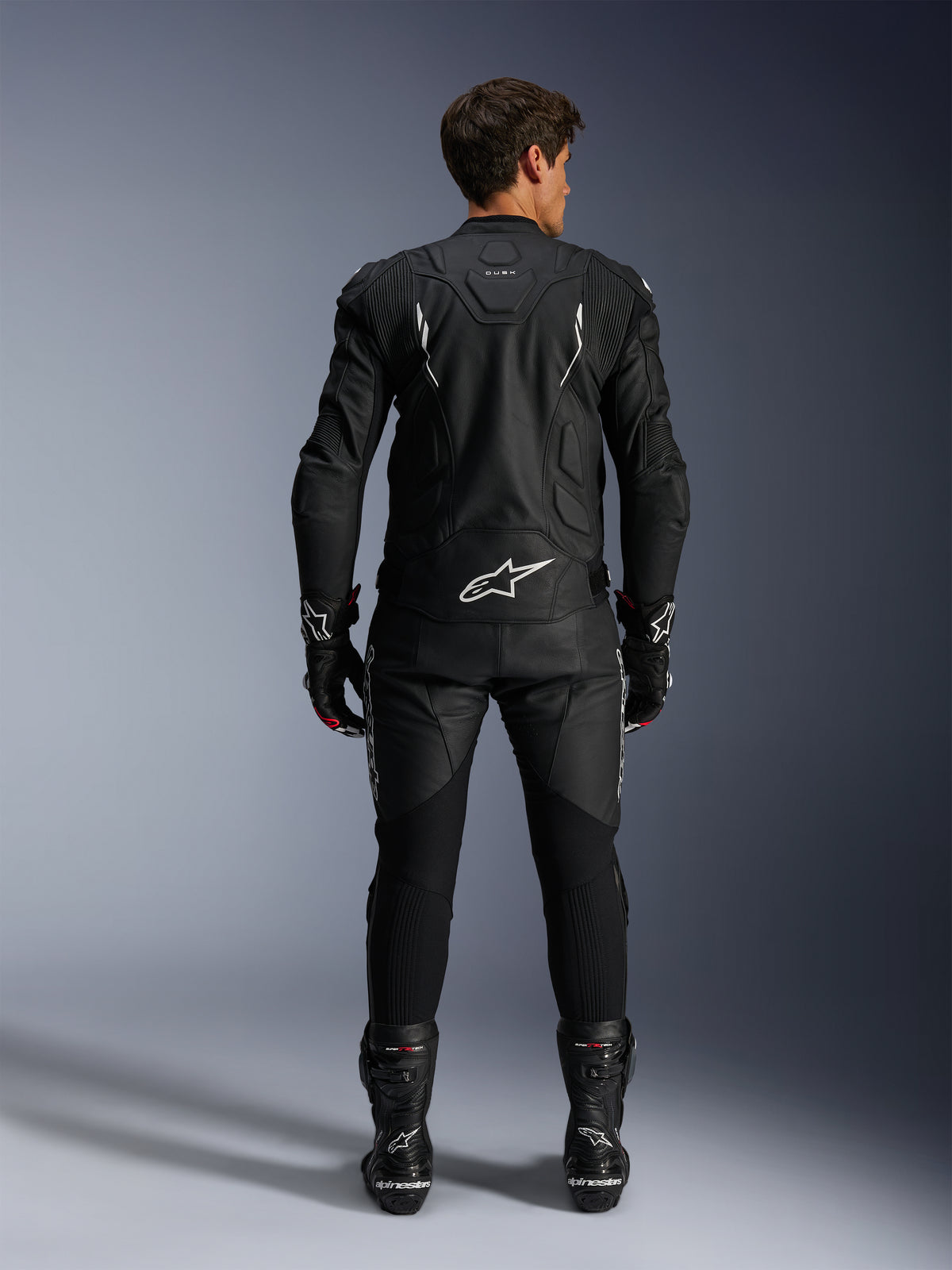 Alpinestars giacca in pelle Dusk e pantaloni in pelle Missile V3, completo racing da moto da uomo, nero e bianco, vista posteriore.