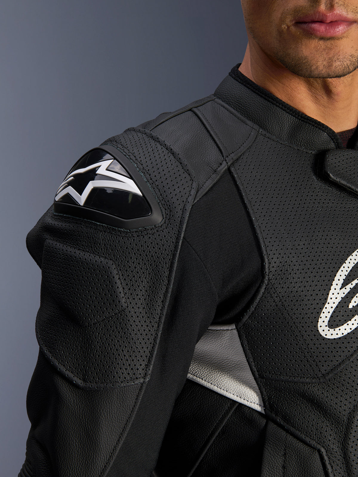 Alpinestars Dusk Airflow Leather Jacket, nero e bianco, vista ravvicinata di spalla e torace, con pelle traforata per la ventilazione, protezione per le spalle DFS con logo Alpinestars bianco, design sportivo.