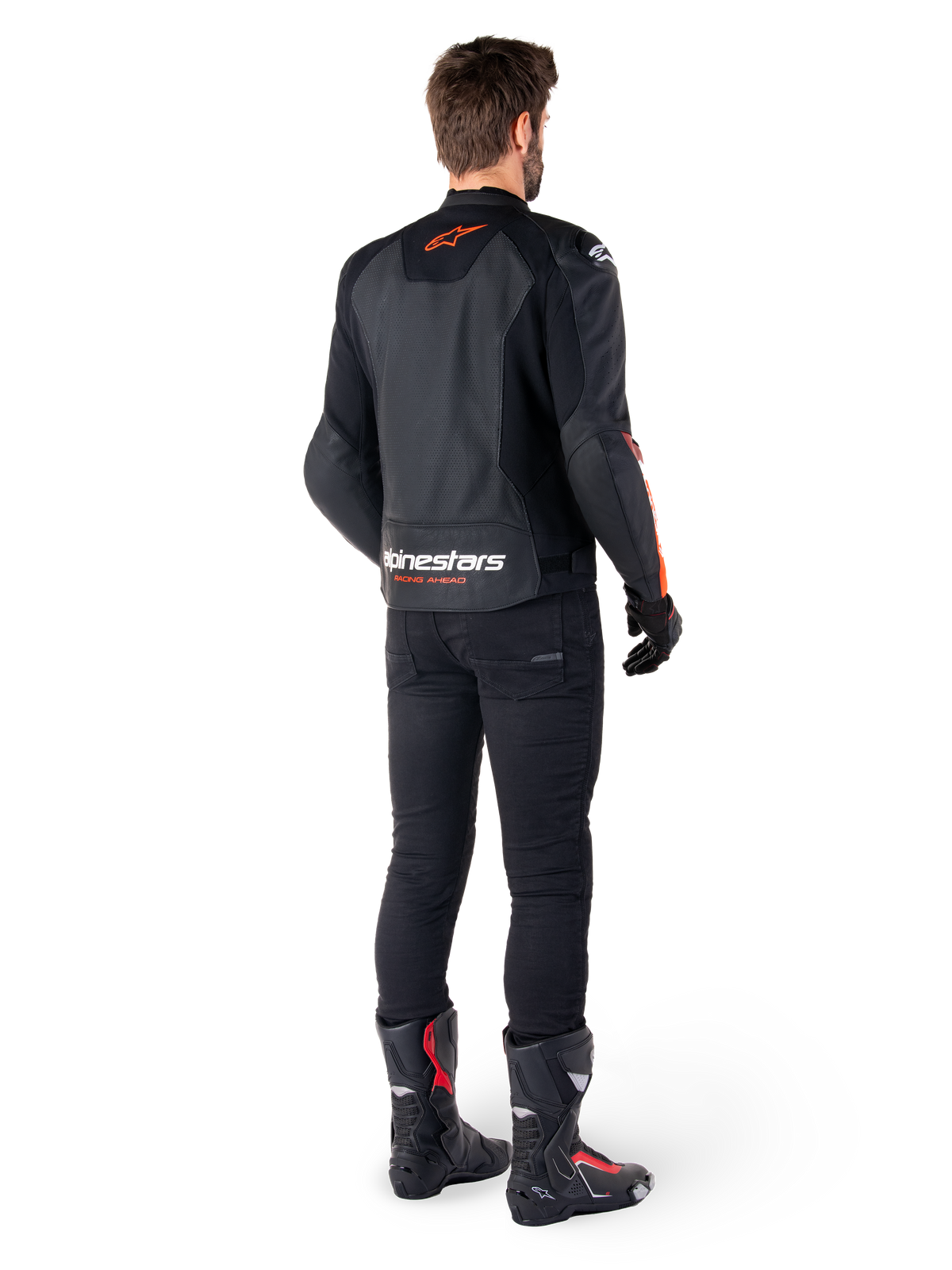 Giacca in pelle Alpinestars Faster V3 Airflow, nero e rosso fluo, vista da dietro su un pilota, con pannelli in pelle traforata e loghi evidenti, indossata con pantaloni neri e stivali da moto, abbigliamento da guida sportiva.