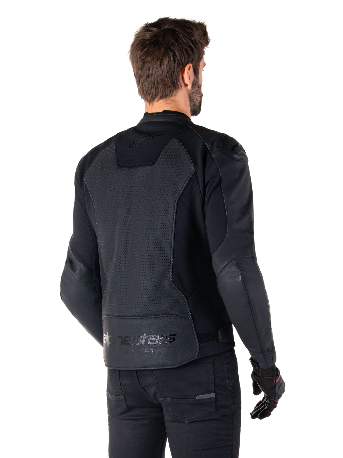 Giacca in pelle Alpinestars Faster V3 Airflow, nero, vista posteriore di un uomo che indossa una giacca da moto sportiva in pelle, con pannelli posteriori traforati, inserti elasticizzati e logo Alpinestars sul bordo inferiore, abbinata a pantaloni e guanti neri