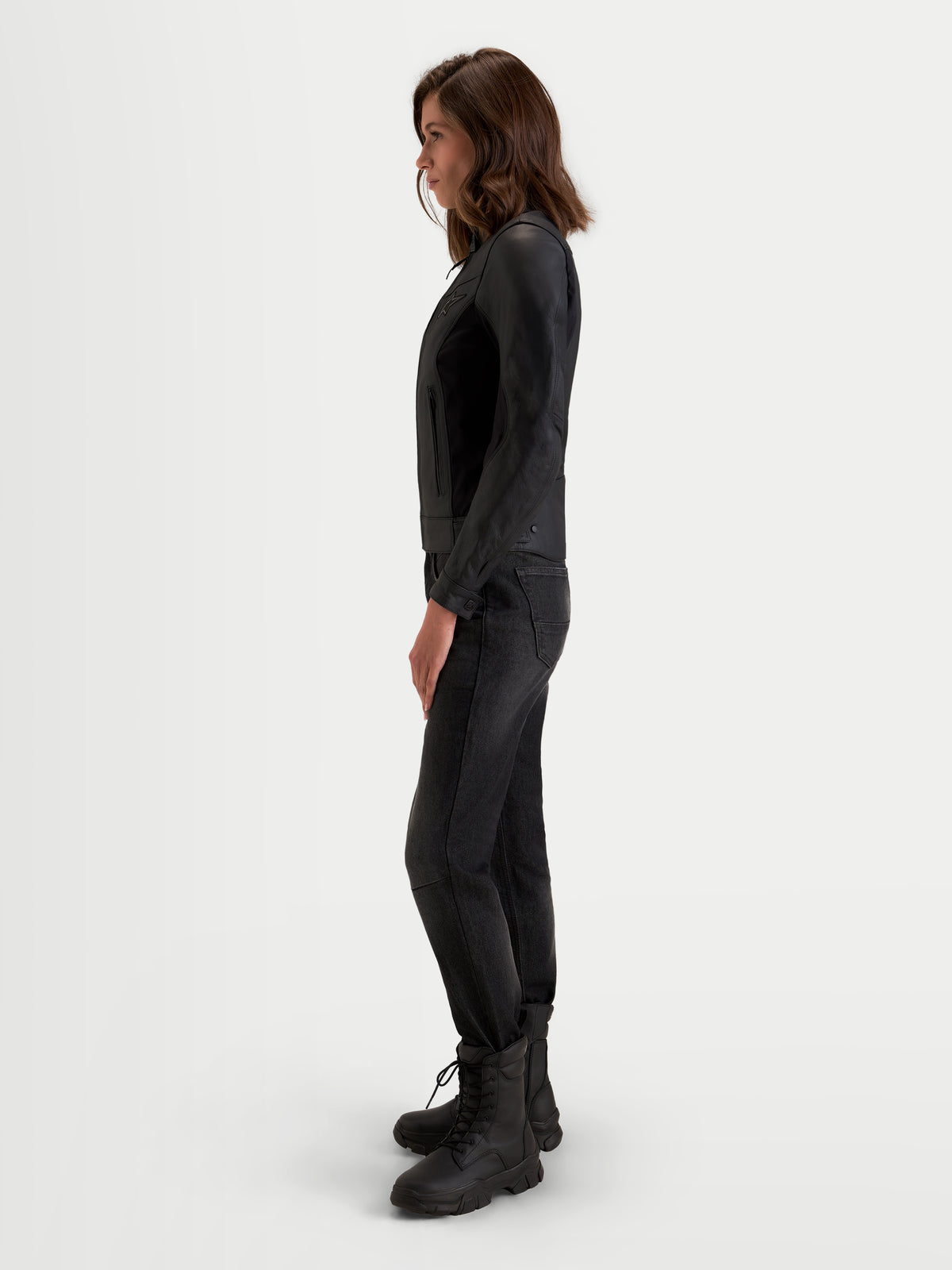 Alpinestars Stella Maver X Giacca di pelle, giacca da moto urbana contemporanea da donna in nero, vista di profilo laterale indossata da una modella che mostra la vestibilità sartoriale e la pregiata struttura in pelle