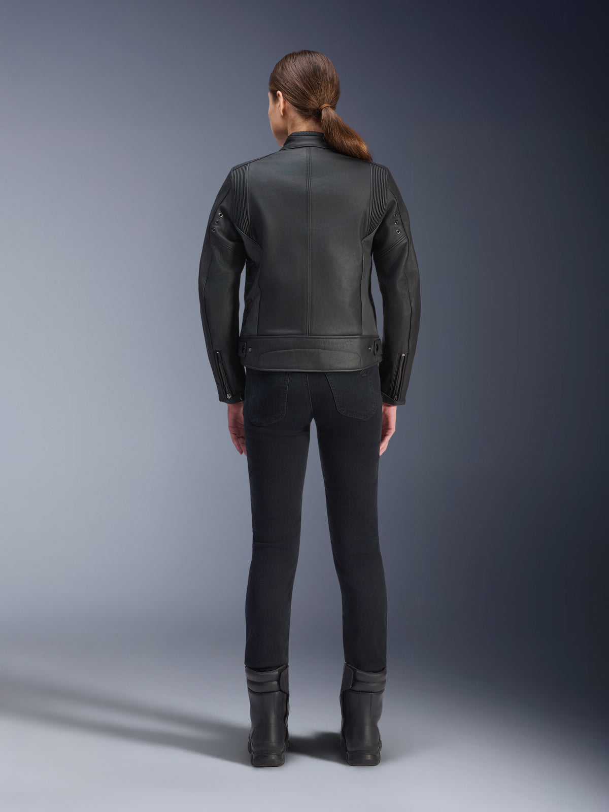 Alpinestars Stella Dyno Leather Jacket, giacca da moto da donna, nero, vista posteriore che mette in risalto la costruzione sartoriale in pelle bovina, design heritage minimalista, indossata con pantaloni e stivali da moto neri per un look urbano