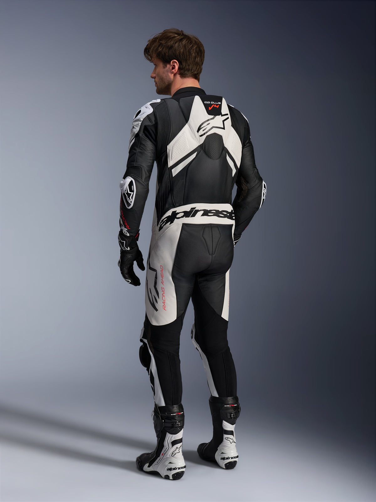 Tuta in pelle Alpinestars GP Plus V4 Sprint 1PC, nera e bianca, vista posteriore con gobba aerodinamica racing da uomo.
