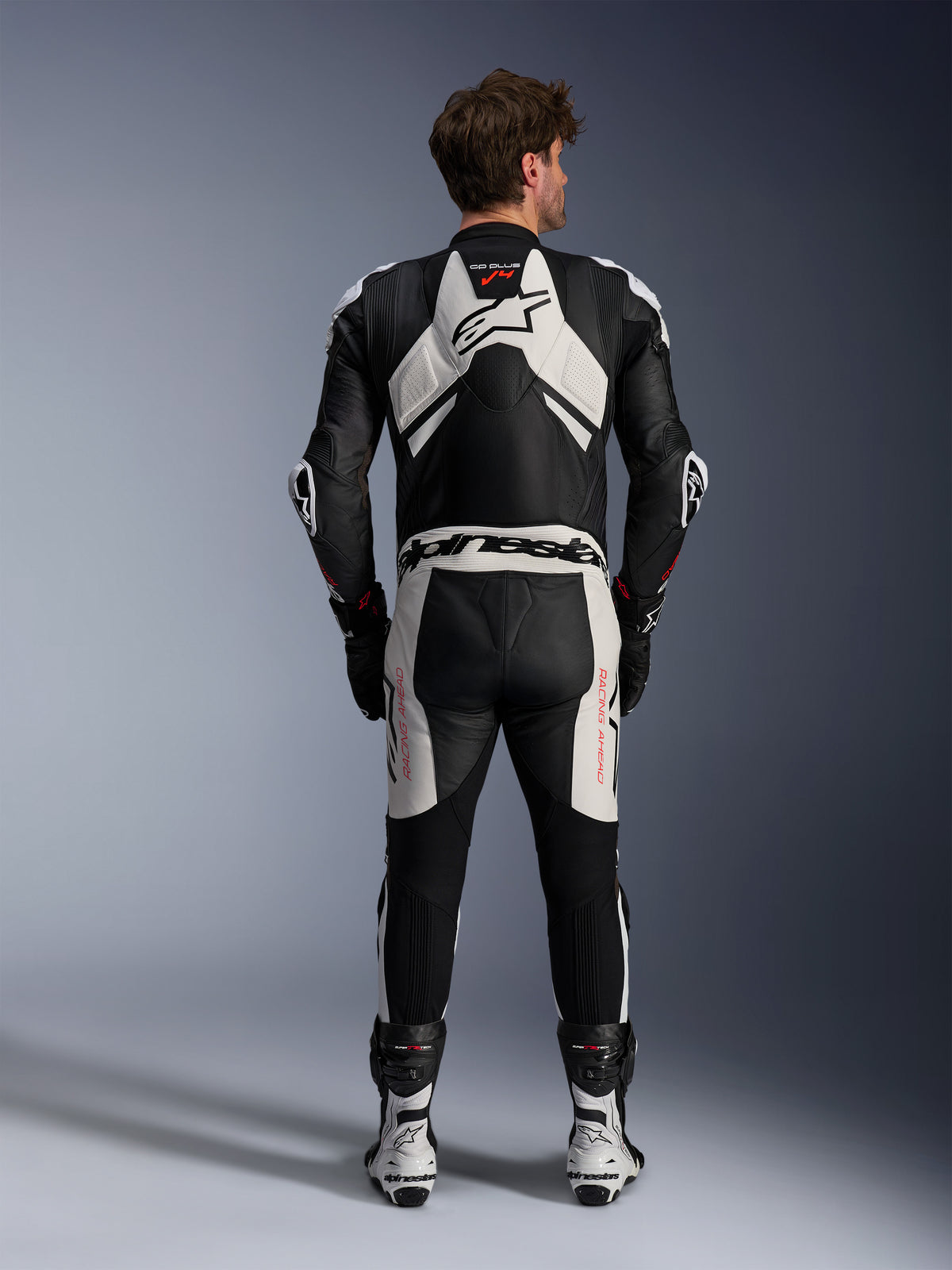 Alpinestars Tuta in pelle GP Plus V4 Sprint 1 Pezzo, tuta da corsa uomo, nero e bianco con rosso fluo, vista posteriore con gobba aerodinamica.