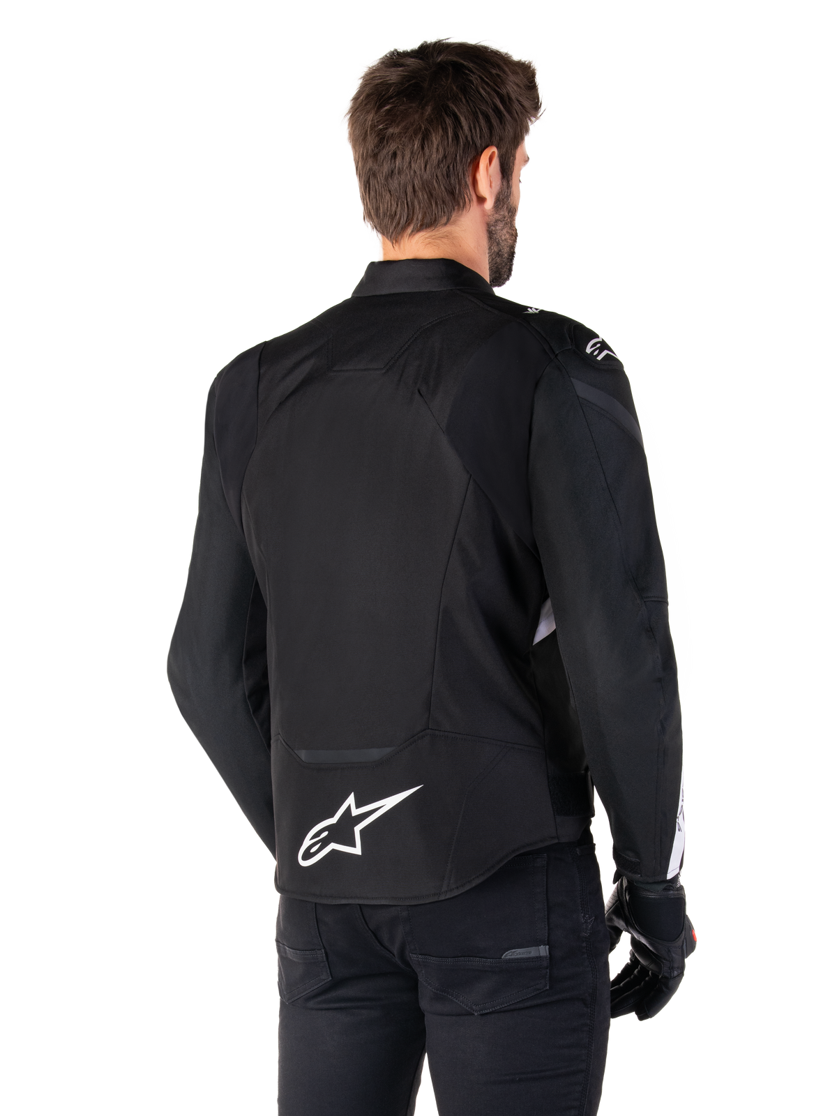 Alpinestars Giacca Impermeabile T-Jaws V4, nero e bianco, vista posteriore, giacca da moto sportiva in tessuto con logo bianco sulla parte bassa della schiena, indossata con guanti e pantaloni neri, con silhouette dalla vestibilità sportiva rivista