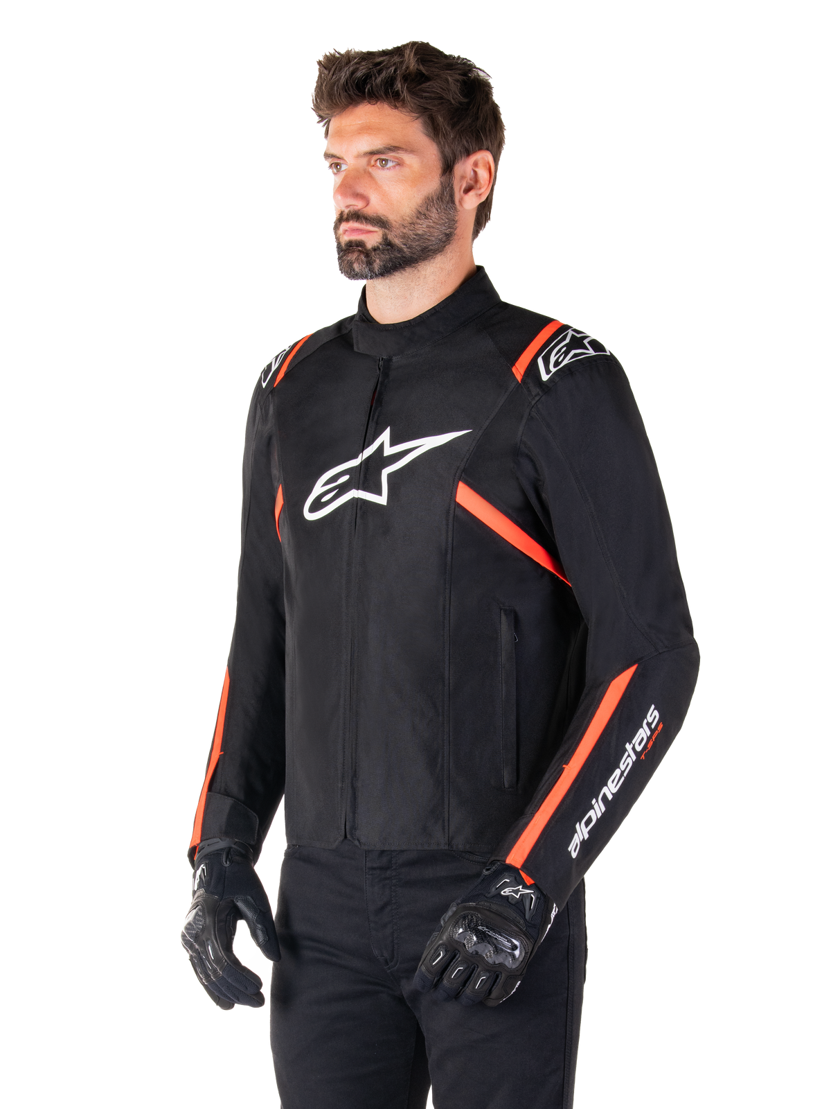Giacca Alpinestars T-SPS V2 Waterproof, nero, bianco e rosso fluo, indossata da un modello con guanti e pantaloni neri, con un logo Alpinestars bianco sul petto e accenti rosso fluo su spalle e maniche, design sportivo in tessuto