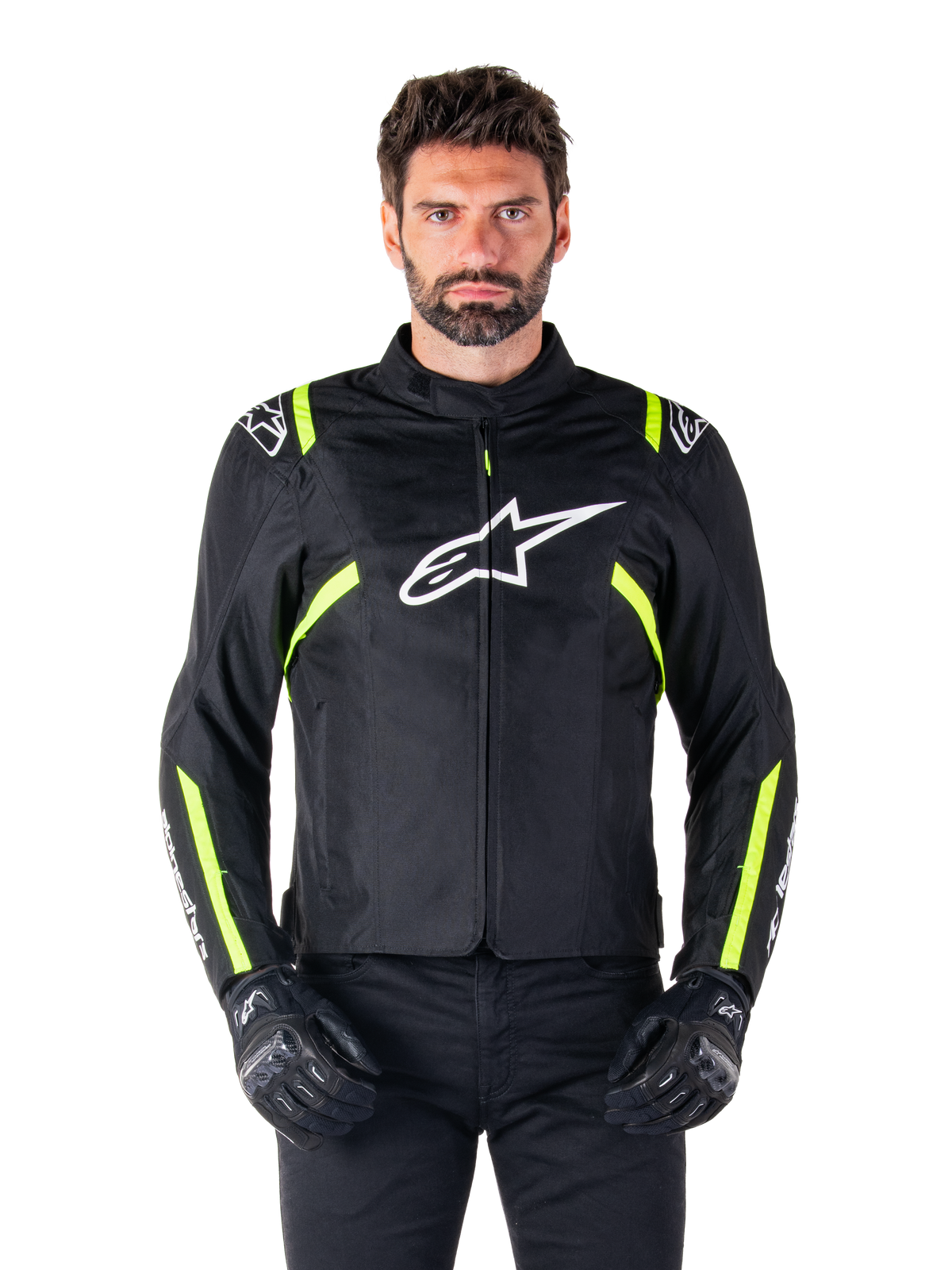 Alpinestars T-SPS V2 Waterproof Jacket, giacca da moto, nero con accenti bianco e giallo fluo, indossata da un modello con guanti neri, con logo a stella bianco sul petto e strisce giallo neon su maniche e spalle, abbigliamento sportivo in tessuto per ogni condizione climatica