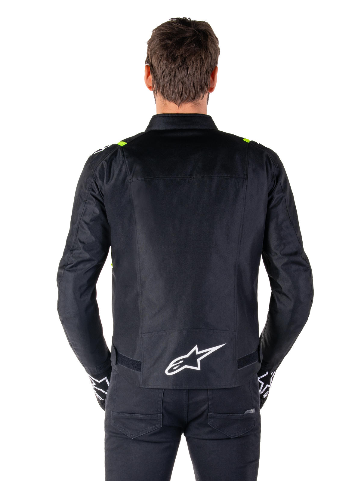 Giacca Alpinestars T-SPS V2 Waterproof, vista posteriore, nero con accenti giallo fluo sulle spalle e logo a stella bianco sulla parte bassa della schiena, giacca da moto in tessuto con silhouette sportiva, indossata da un modello maschile