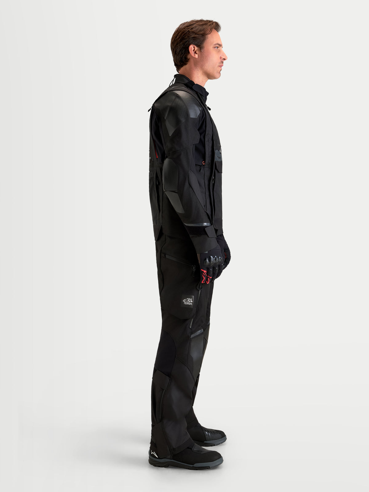 Alpinestars Harok V2 Drystar Gear Set, giacca e pantaloni da moto adventure da uomo, colore nero, vista laterale su un modello che indossa abbigliamento impermeabile in tessuto