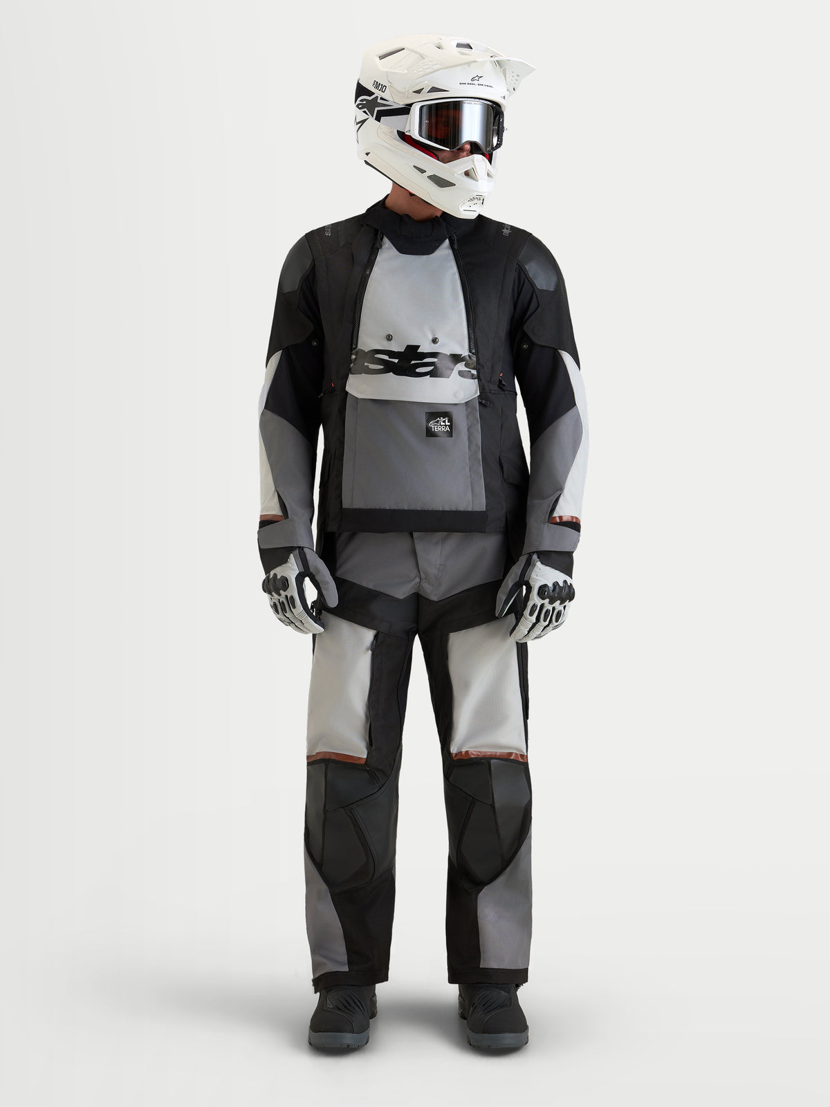Alpinestars Harok V2 Drystar Giacca, giacca da moto adventure da uomo in grigio scuro, grigio ghiaccio e nero, indossata con equipaggiamento coordinato, casco e guanti, certificata AA