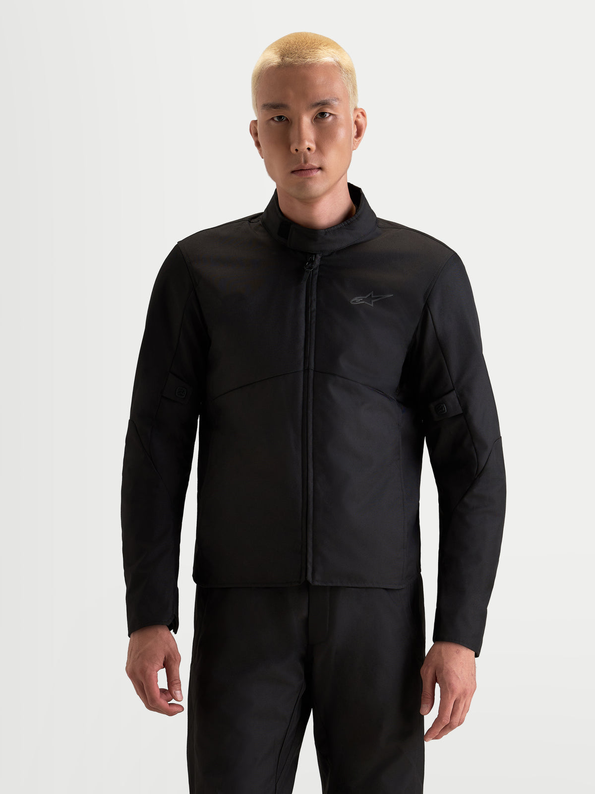 Alpinestars C-1 Waterproof Giacca, giacca da moto urbana da uomo in nero, vista anteriore indossata da un modello che mostra la struttura in tessuto impermeabile e il collo alto