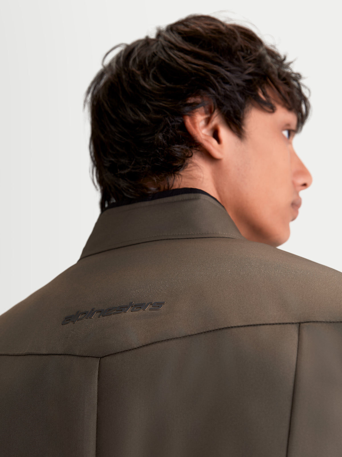 Alpinestars C 1 Waterproof Giacca, giacca da moto urbana contemporanea da uomo in marrone noce e nero, vista posteriore ravvicinata del colletto e del logo sul retro indossata da un modello