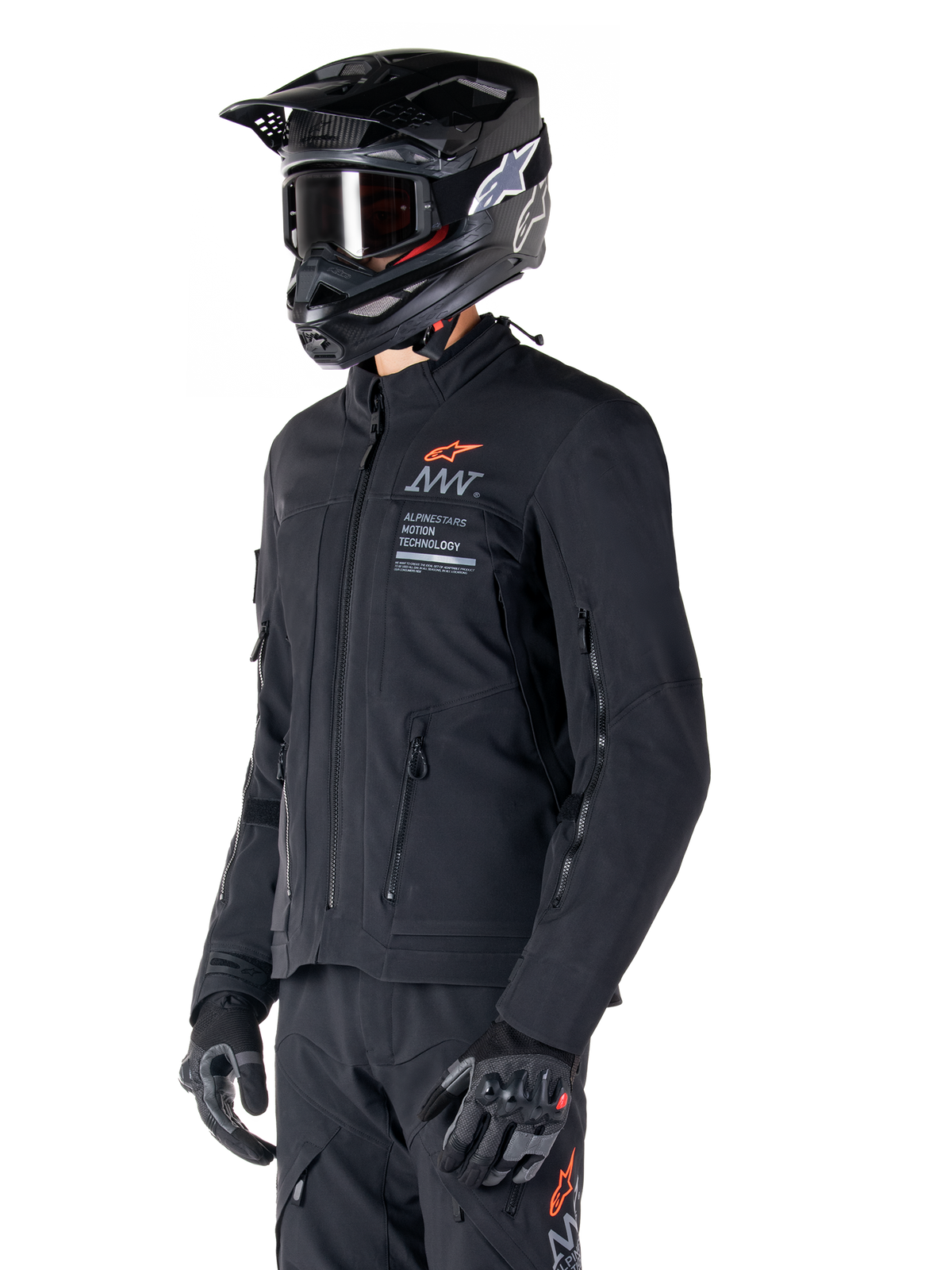 Giacca Alpinestars AMT-8 Stretch Drystar® XF, nera, indossata da un pilota con pantaloni e guanti adventure abbinati, completa di casco da motocross nero e occhiali, aperture di ventilazione con cerniera su petto e braccia, marchio Alpinestars Motion Technology con logo arancione, abbigliamento adventure-touring premium