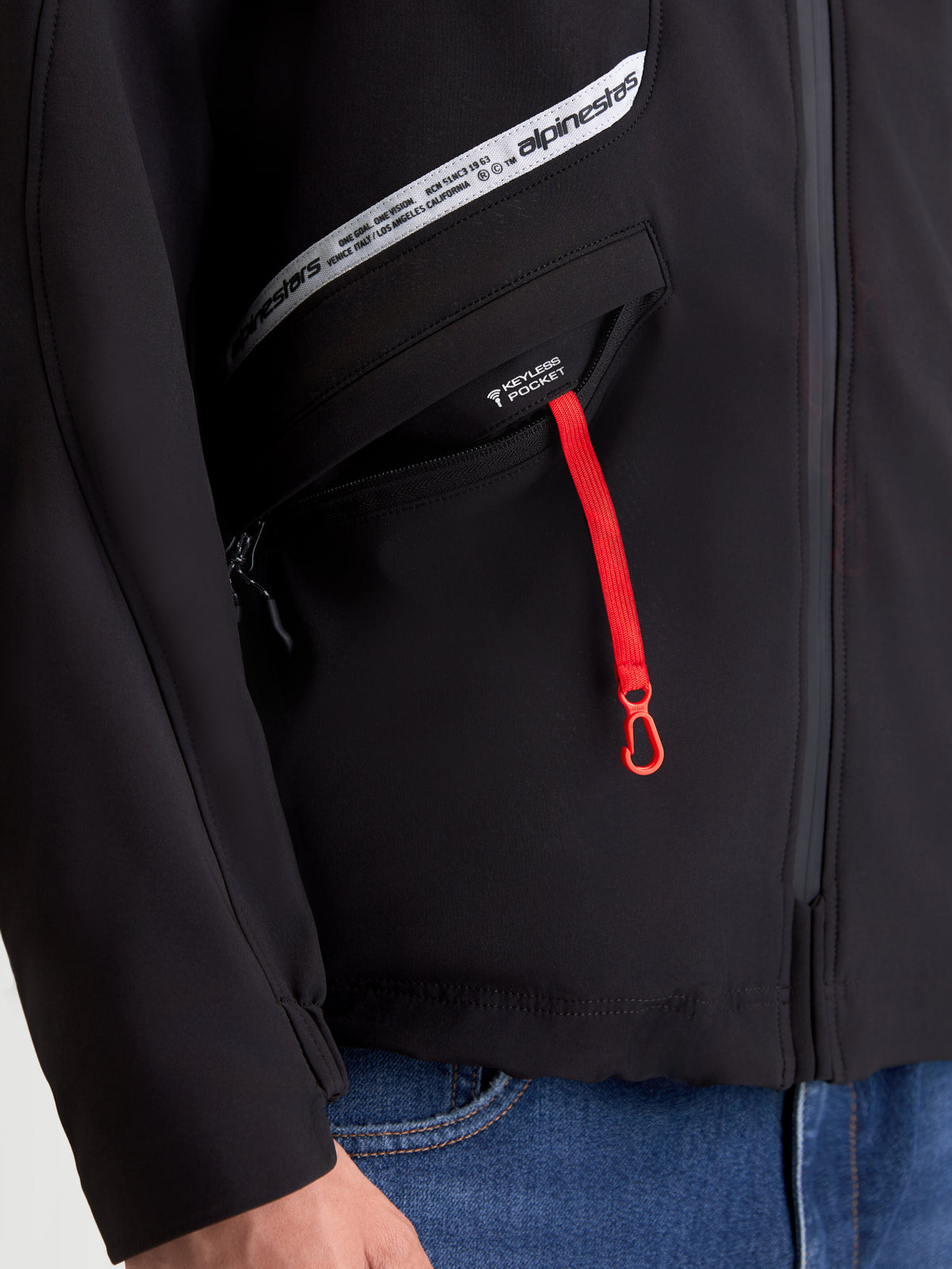 Alpinestars C 5 Drystar Giacca, giacca da moto urbana da uomo, nero, vista ravvicinata della tasca keyless con tiralampo rosso e grafica del marchio sul petto
