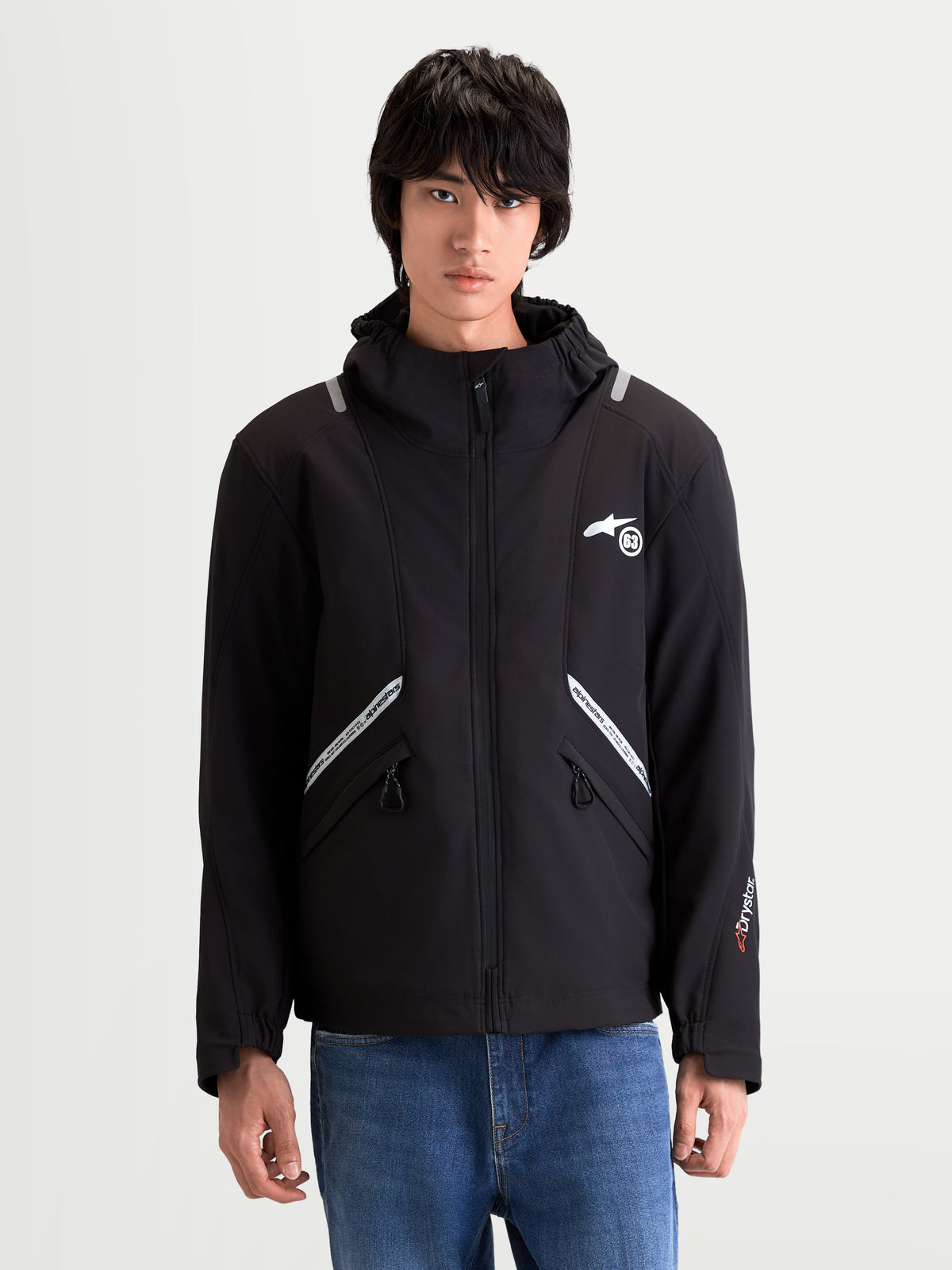 Alpinestars C 5 Drystar Giacca, giacca da moto urbana contemporanea da uomo in colore nero, vista anteriore su un modello che indossa abbigliamento da guida softshell impermeabile con cappuccio integrato e dettagli riflettenti