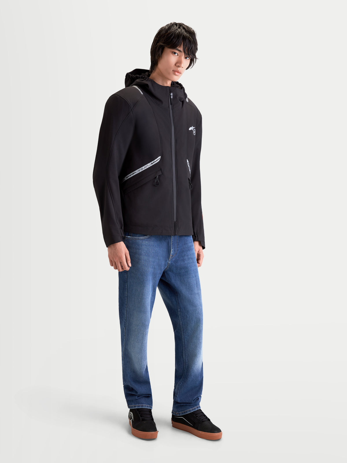 Alpinestars C 5 Drystar Giacca, giacca da moto urbana contemporanea da uomo in nero, indossata da un modello, con struttura softshell impermeabile, cappuccio integrato e dettagli riflettenti