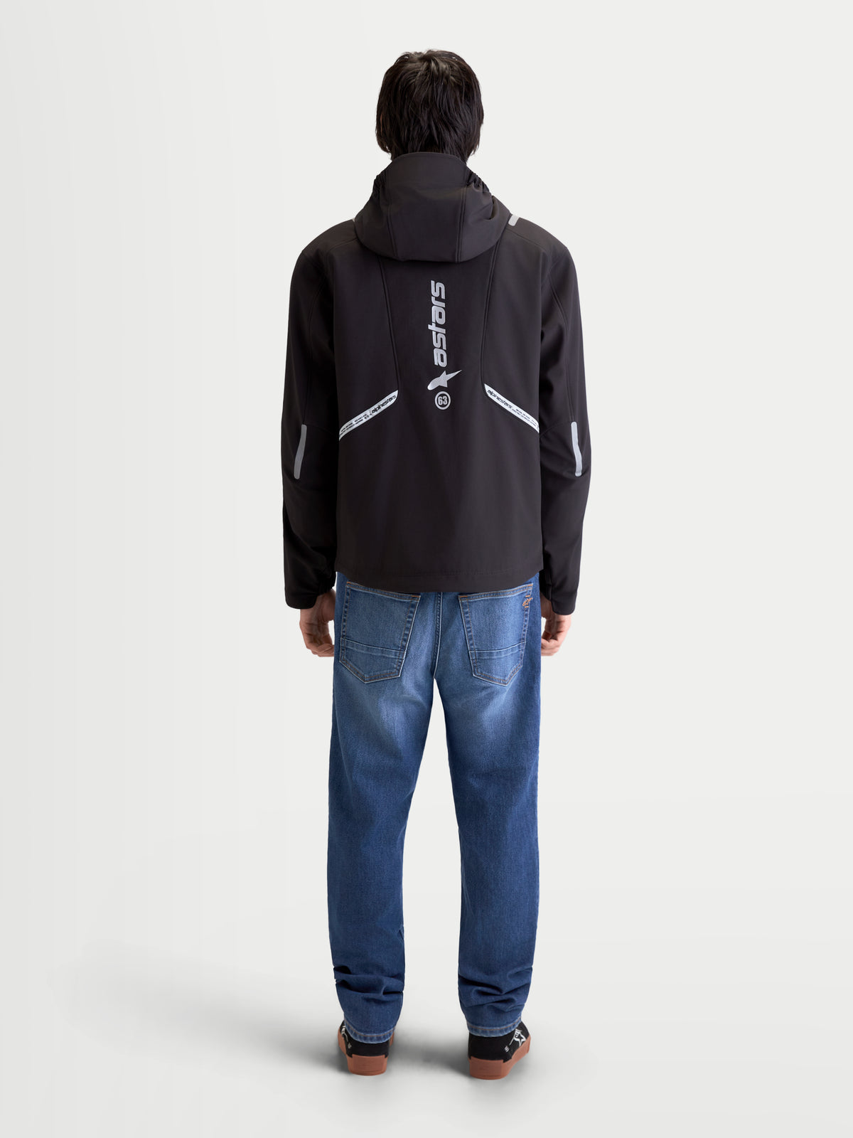 Alpinestars C 5 Drystar Giacca, giacca da moto urbana contemporanea da uomo in nero, vista posteriore su un modello che indossa la giacca con cappuccio integrato e dettagli riflettenti