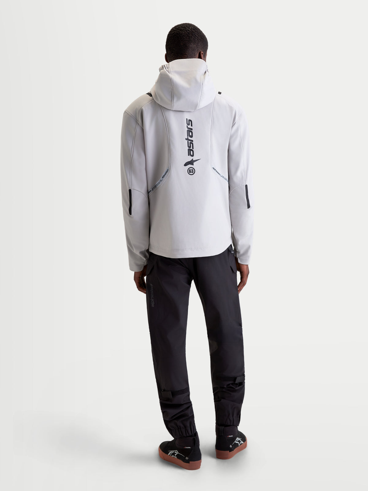 Alpinestars C 5 Drystar Giacca, giacca da moto urbana contemporanea da uomo in grigio chiaro e nero, vista posteriore con cappuccio integrato e marchio riflettente indossata da un modello