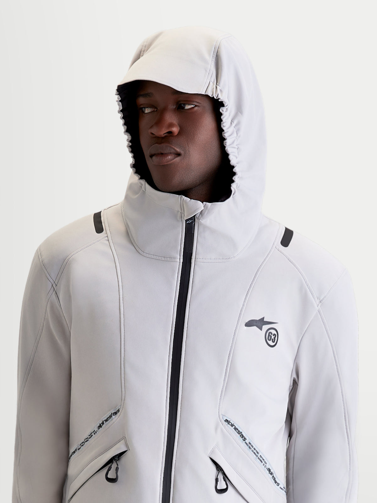 Alpinestars C 5 Drystar Giacca, giacca da moto urbana contemporanea da uomo in grigio chiaro e nero, vista a mezza figura di un modello che indossa la giacca con cappuccio integrato sollevato