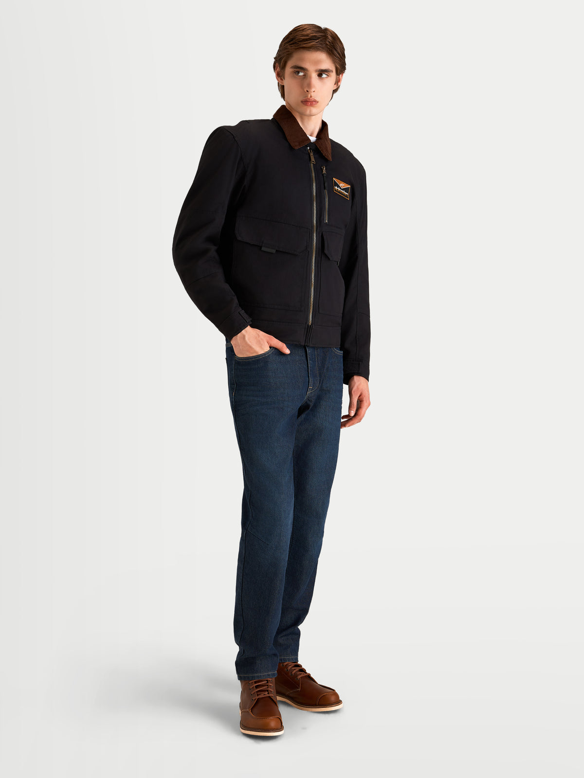 Alpinestars Mustang Wp Giacca, giacca da moto urbana contemporanea da uomo in antracite scuro e marrone scuro, vista a tre quarti su un modello che indossa abbigliamento da moto in tessuto stile workwear con colletto in velluto a coste