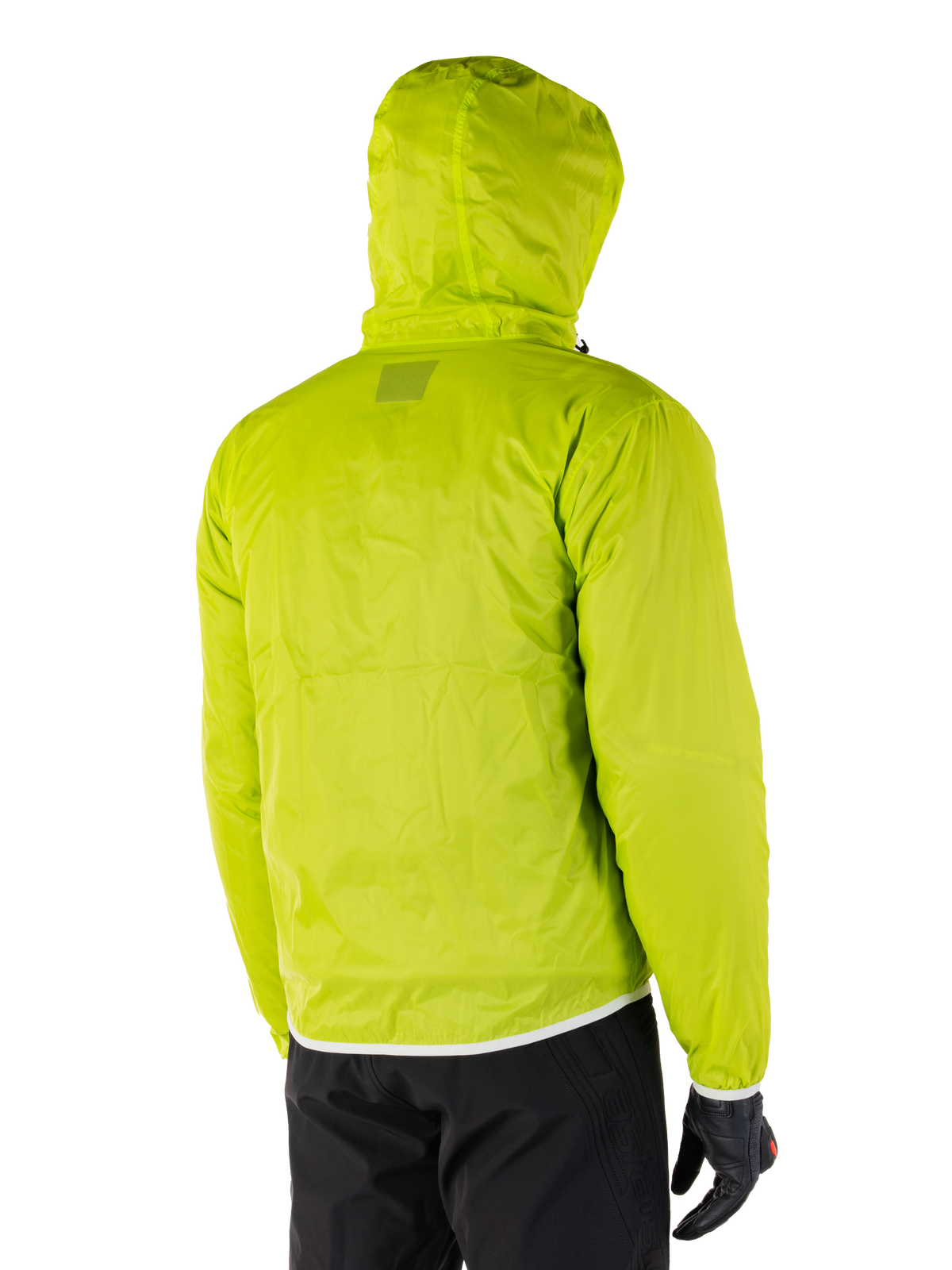 Alpinestars Mohobbs Waterproof Jacket, fodera antipioggia ripiegabile in Lime Punch, vista posteriore dello strato impermeabile verde neon con cappuccio, indossata con pantaloni da moto e guanti neri