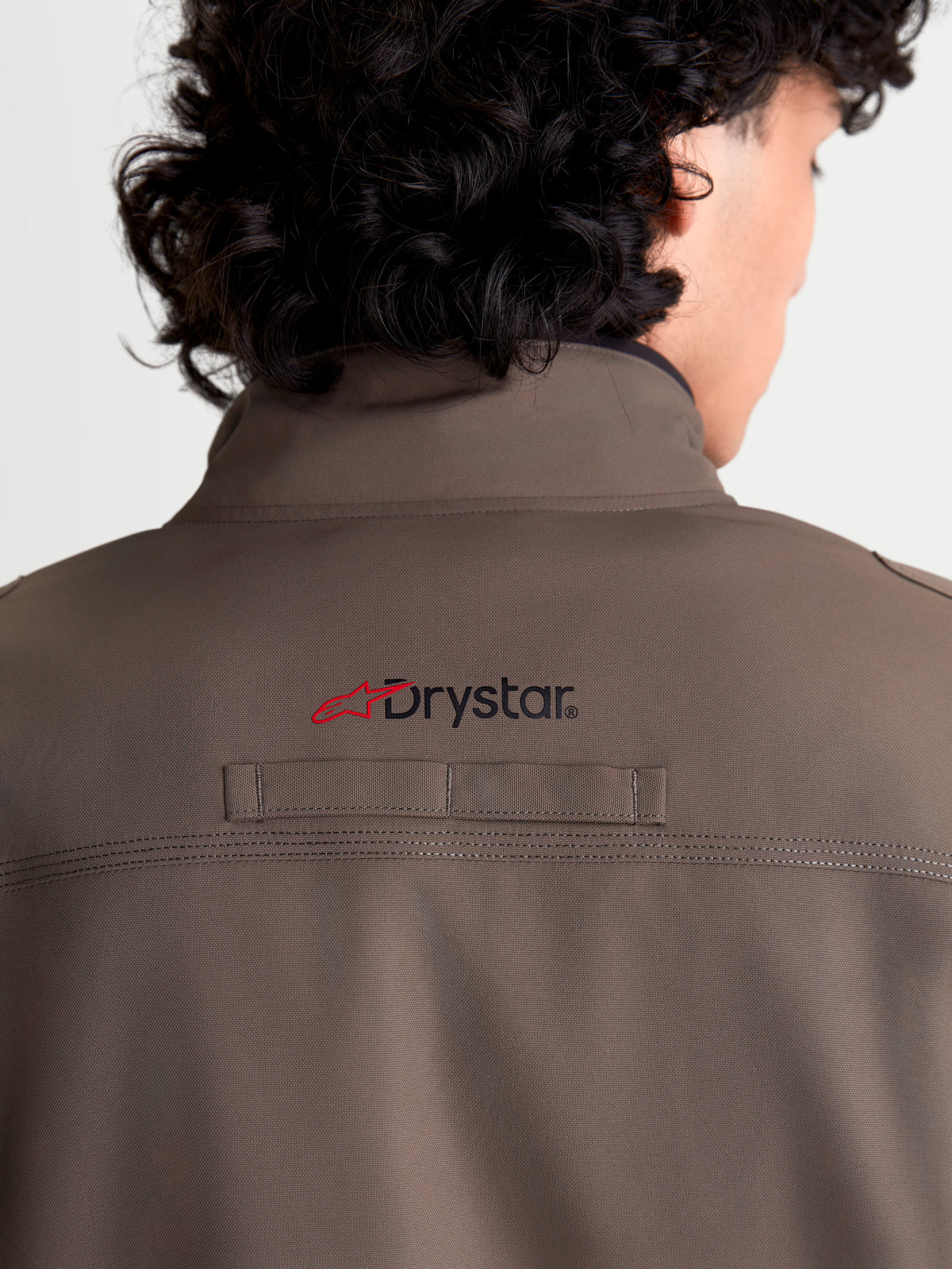 Alpinestars Altan Drystar Giacca da moto urbana da uomo, marrone noce e nero, vista posteriore ravvicinata che mostra il colletto caldo integrato, il marchio Drystar sul retro e la resistente struttura in tessuto sintetico