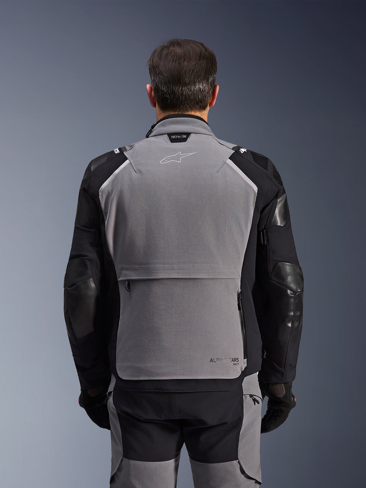 Alpinestars Andes Pro Drystar® XF Jacket, vista posteriore, grigio scuro e nero, giacca adventure touring con ampia tasca posteriore, marchio Tech-Air® Ready sul colletto e pannelli rinforzati sui gomiti.