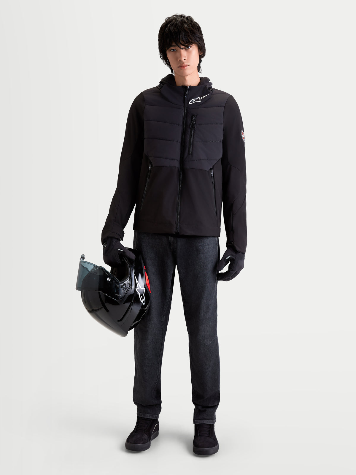Alpinestars Therma Tech WP Giacca, giacca da moto urbana da uomo, nero, vista frontale su un modello che indossa guanti coordinati e tiene un casco, con costruzione con saldatura a sonico e tessuto softshell