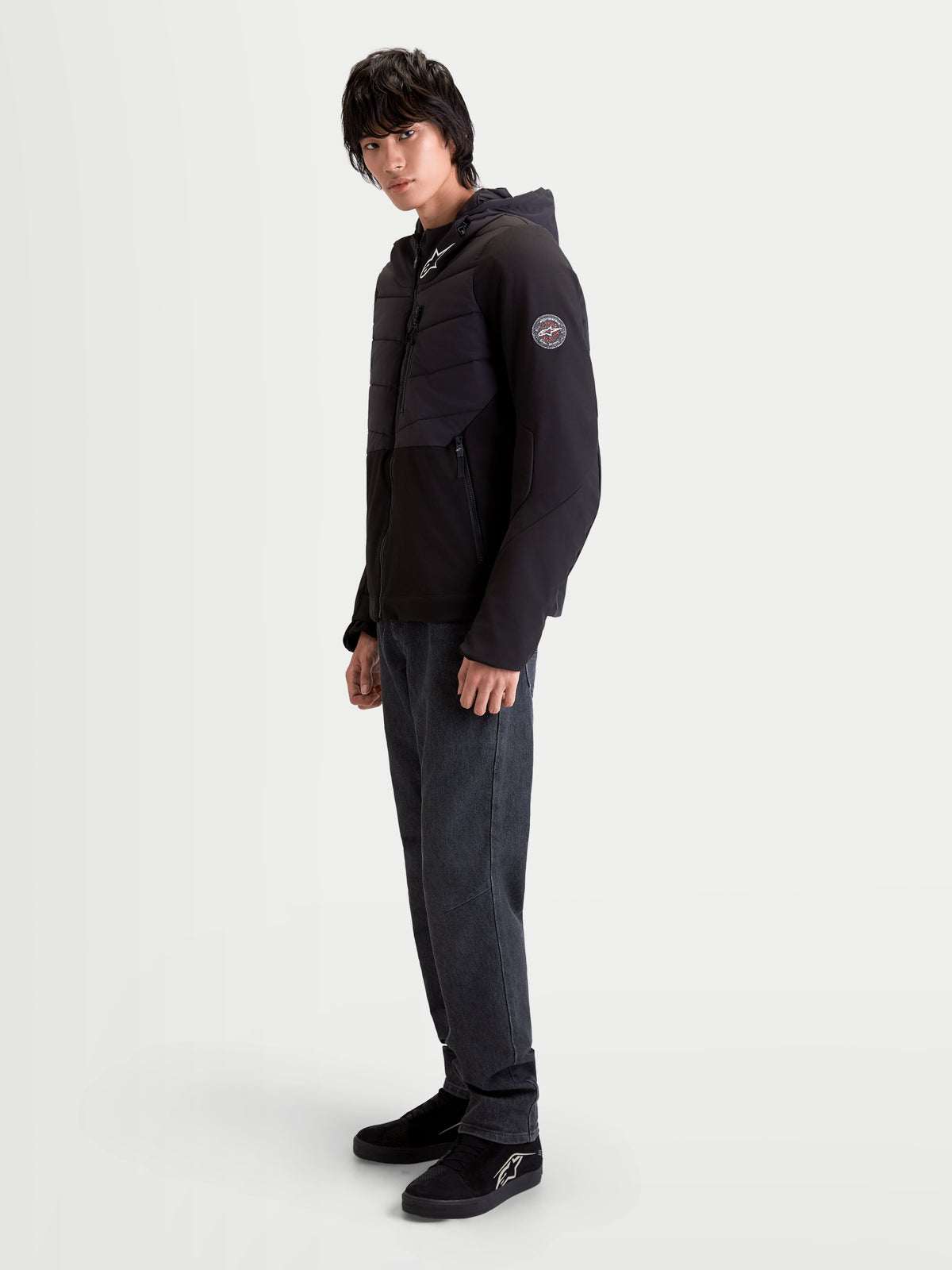 Alpinestars Therma Tech WP Giacca, giacca da moto urban contemporary da uomo, colore nero, vista laterale indossata da un modello che mostra la struttura trapuntata saldata a sonico e il cappuccio integrato