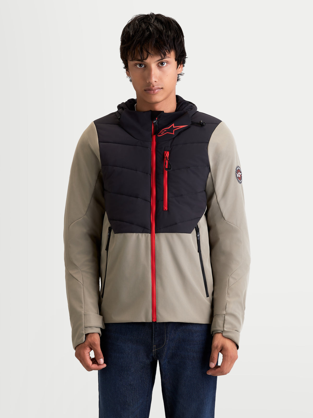 Alpinestars Therma Tech Wp Giacca, giacca da moto urban contemporary da uomo in nero e vetiver, vista anteriore su un modello che indossa la giacca termica in tessuto con cappuccio e accenti con zip rossa