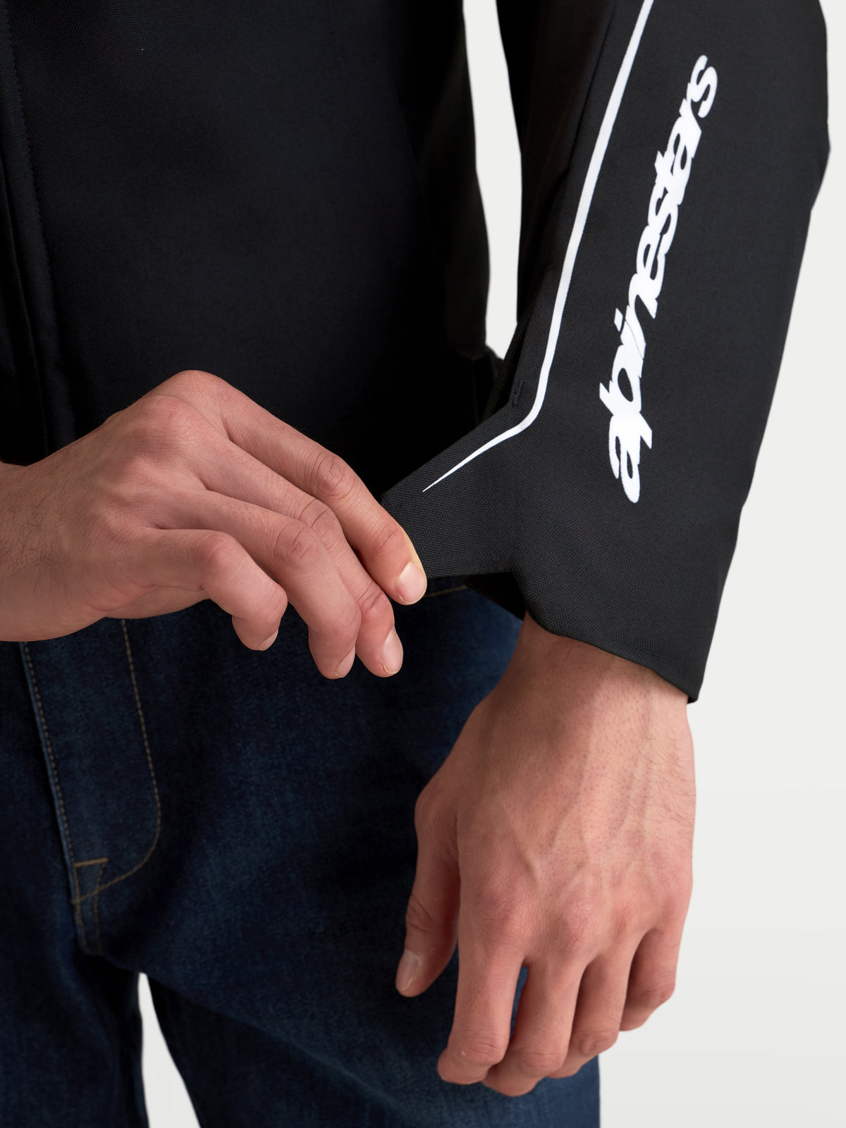 Alpinestars Zaca V2 Waterproof Giacca, dettaglio della chiusura del polsino e della costruzione ergonomica, nero e bianco con logo Alpinestars lungo la manica