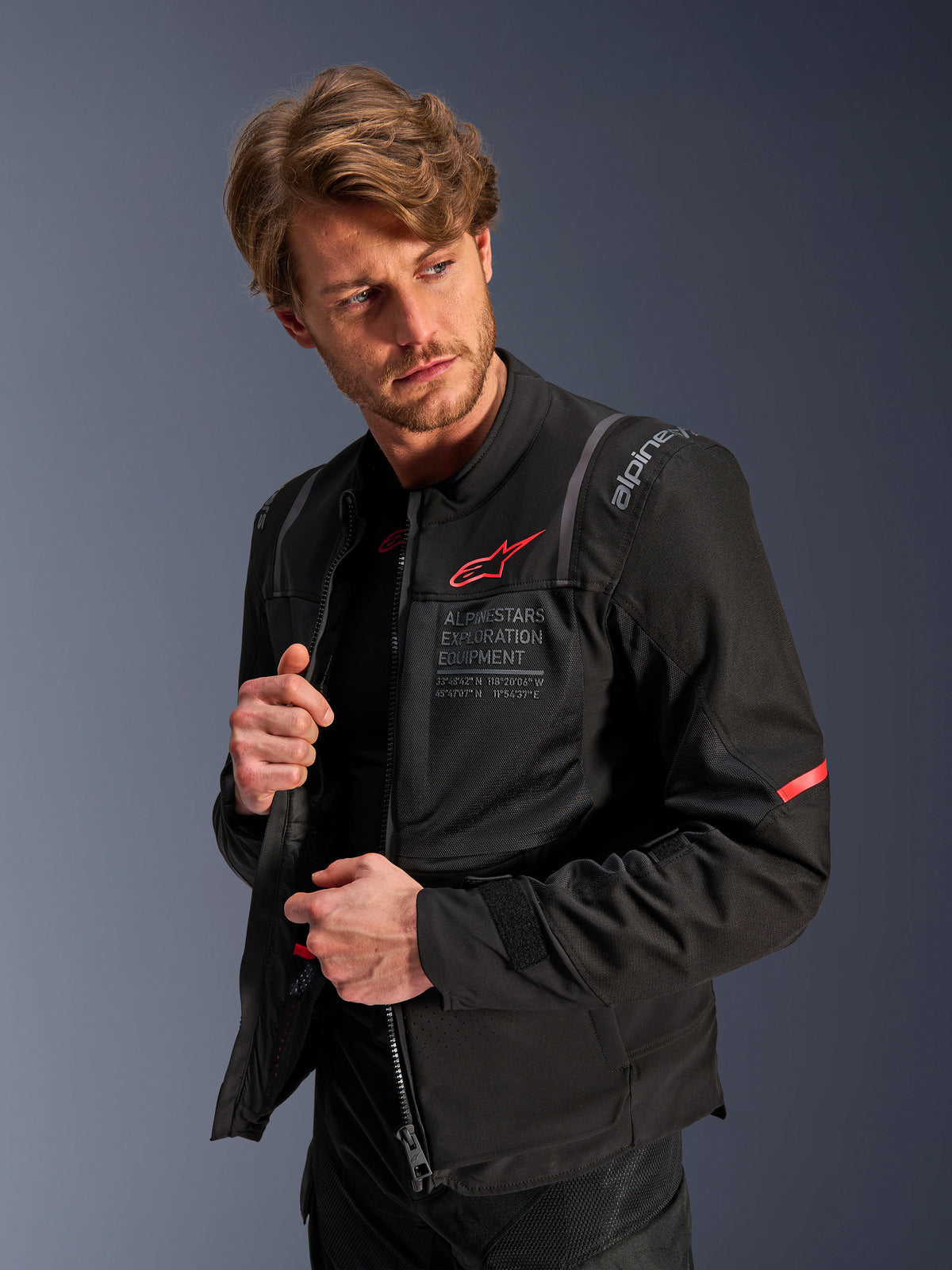 Alpinestars giacca ST-2 Air, giacca da moto touring da uomo nera con pannelli in mesh e logo rosso, indossata da un modello.