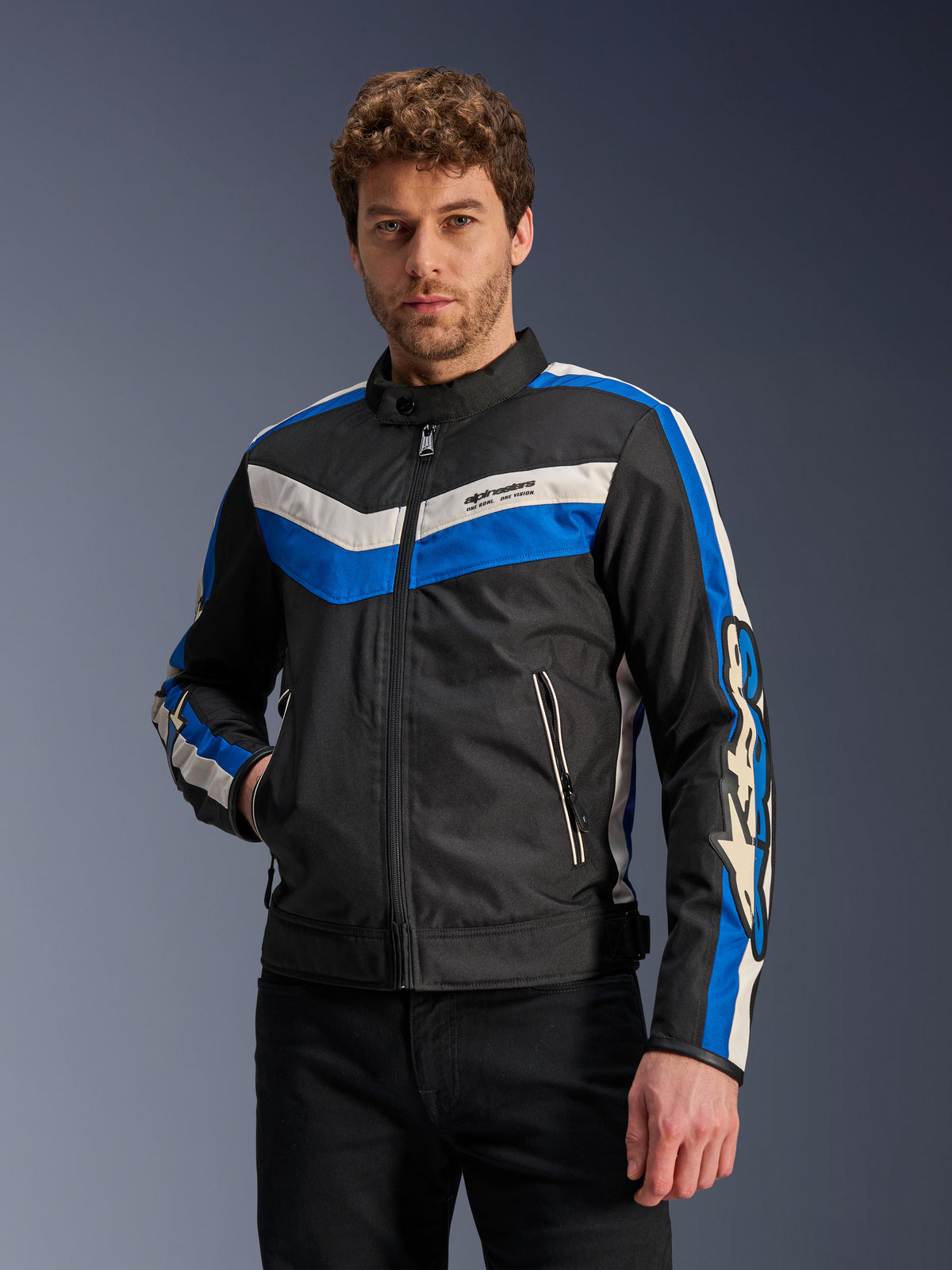 Giacca Alpinestars T-Dyno WR in Nero Blu Ecru, giacca da moto in tessuto caratterizzata da strisce chevron blu e bianco panna su petto e maniche, indossata da un modello