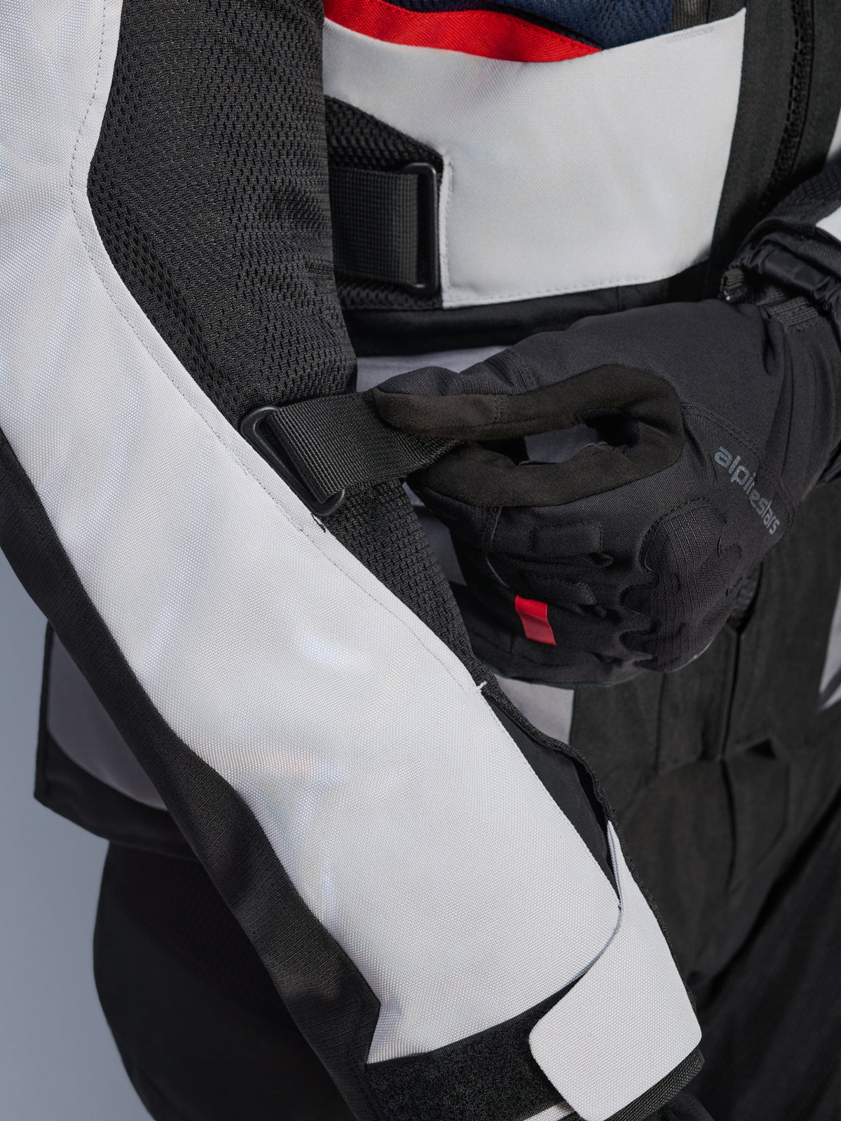 Alpinestars Andes Air Drystar® Jacket in Deep Blue Black Ice Gray, vista ravvicinata della cinghia regolabile sulla manica e dei pannelli di ventilazione in rete, resistente costruzione in tessuto per l'adventure touring