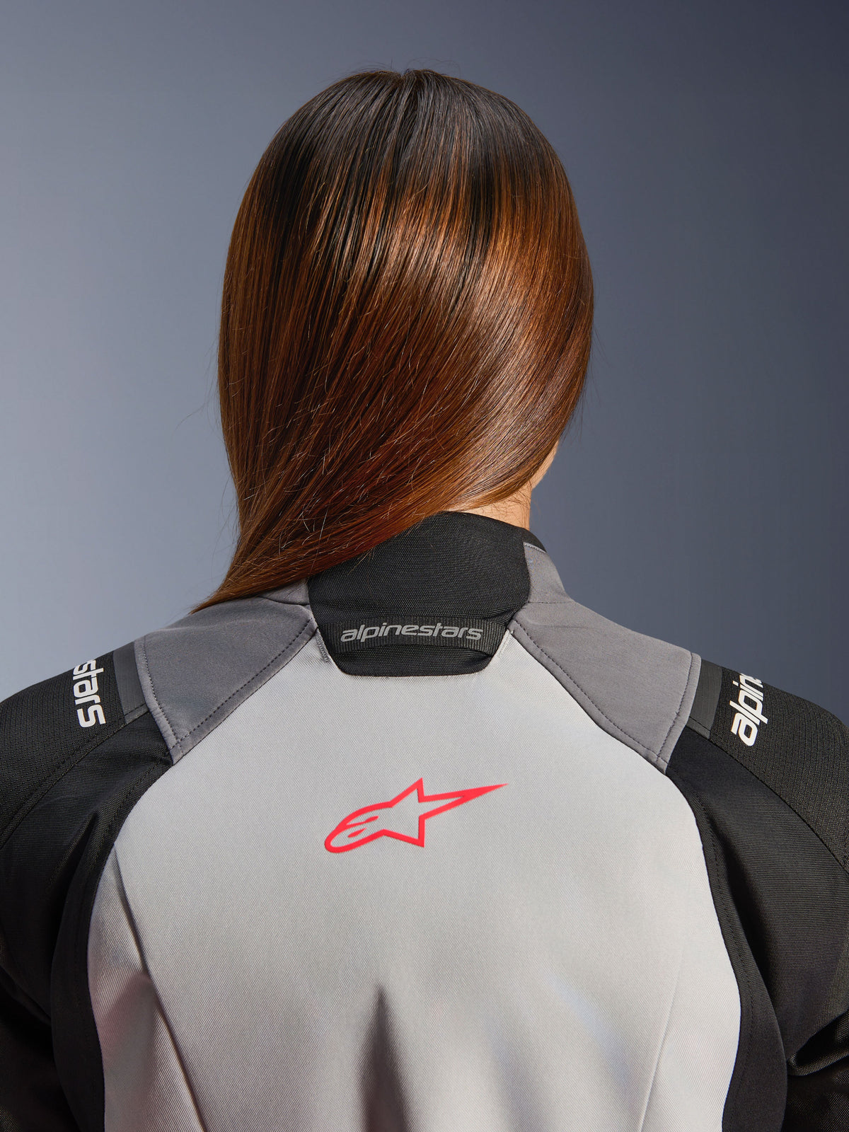 Alpinestars Giacca Stella Andes V4 Drystar, giacca da moto adventure da donna, grigio ghiaccio e nera, dettaglio posteriore con logo corallo fluo, membrana Drystar impermeabile e traspirante.