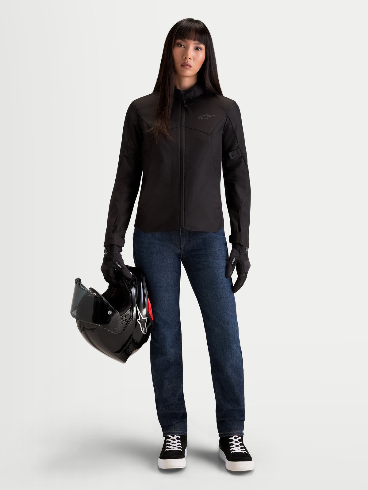 Alpinestars Stella C-1 Waterproof Giacca, giacca da moto urbana da donna in nero, vista frontale indossata da una modella che tiene un casco