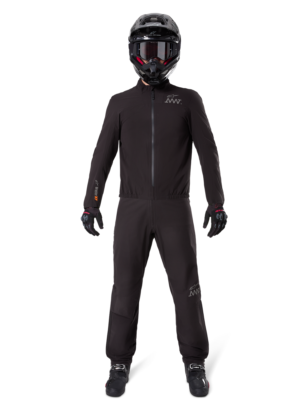 Motociclista che indossa la fodera per pantaloni Alpinestars AMT-8 Stretch Drystar® XF e la giacca coordinata, abbigliamento tecnico completamente nero impermeabile e antivento, con casco, guanti e stivali neri, design elegante per adventure touring.