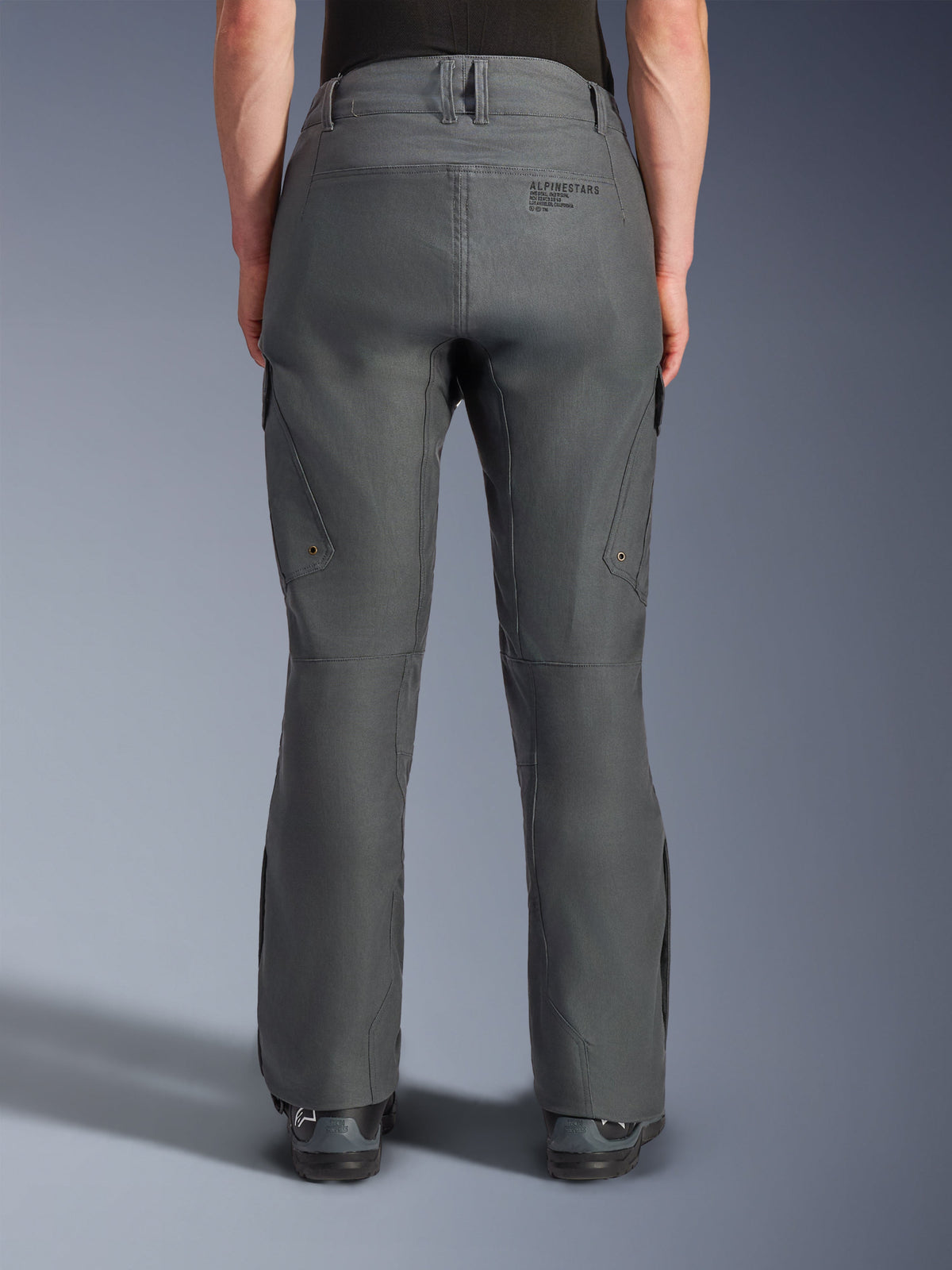 Pantaloni Alpinestars Borrego Drystar®, pantaloni da moto adventure, grigio antracite, vista posteriore che mostra la costruzione in tessuto con aspetto tela cerata, branding Alpinestars sul retro, tasche cargo e passanti per cintura, design robusto e resistente per la guida adventure
