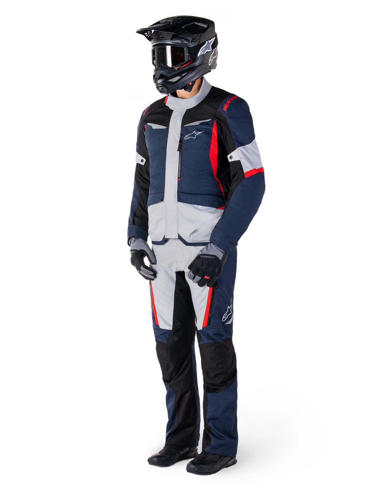 Pantaloni Alpinestars St-1 Waterproof, pantaloni da adventure touring, blu scuro, nero e rosso acceso, indossati con giacca da touring coordinata, casco nero, guanti e stivali, con pannelli grigio chiaro, accenti rossi e marchio Alpinestars, progettati per la guida in ogni condizione atmosferica
