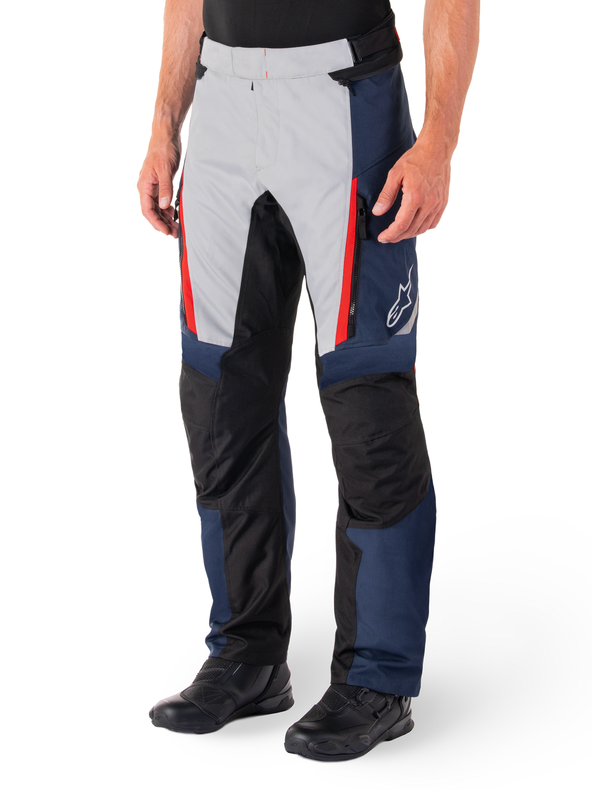 Pantaloni Alpinestars St-1 Waterproof, pantaloni da touring per moto, blu scuro, nero e rosso brillante, caratterizzati da pannelli anteriori grigio chiaro con dettagli delle cerniere rossi, sezioni delle ginocchia rinforzate nere e logo Alpinestars bianco sul lato, indossati con stivali da moto neri.