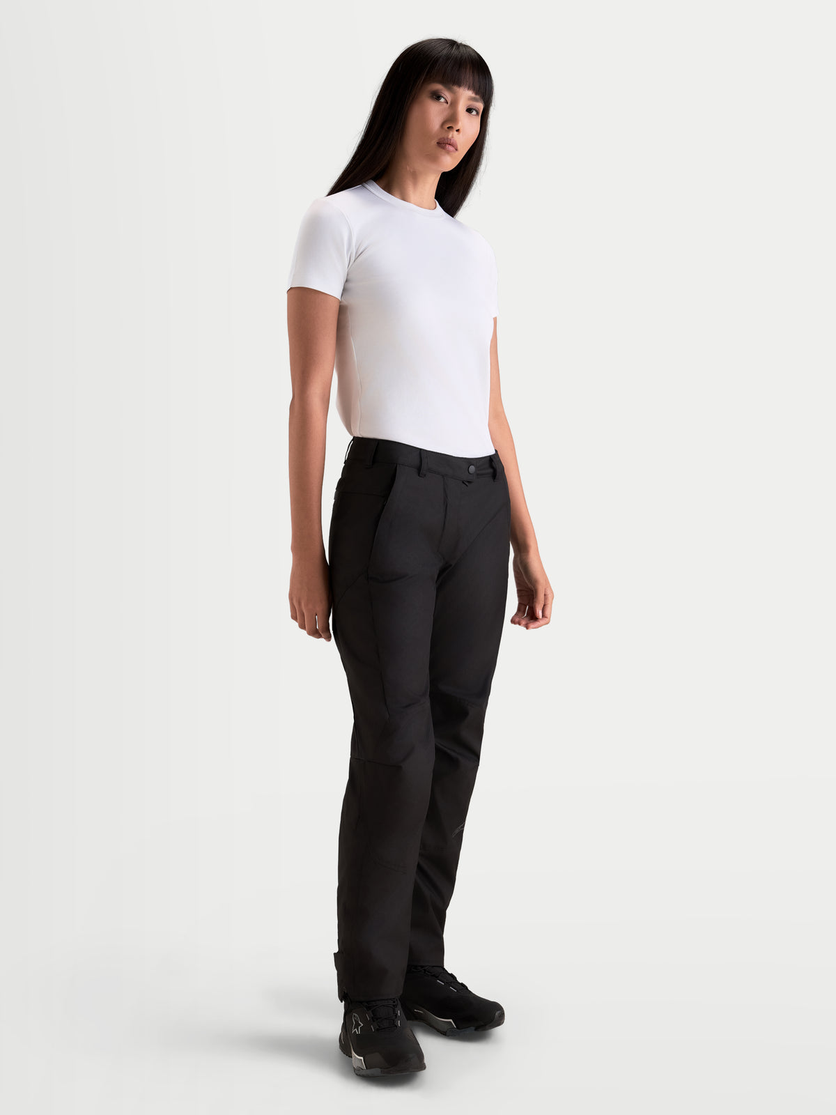Alpinestars Stella C 1 Waterproof Pantaloni, pantaloni da moto urbani da donna, colore nero, con struttura in tessuto a gamba dritta, indossati da una modella con t-shirt bianca, abbigliamento per la guida nella stagione fredda