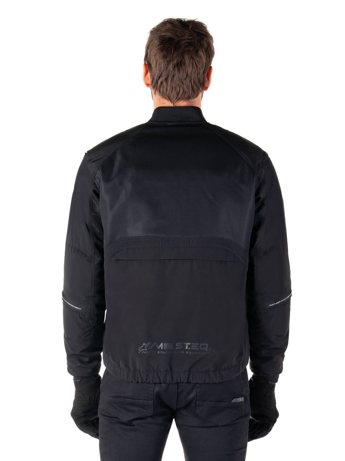 Alpinestars Mootant Waterproof Parka, giacca da moto nera, vista posteriore che mostra la parte superiore in mesh per il flusso d'aria e il logo riflettente MO.ST.EQ. sulla parte bassa della schiena, abbigliamento modulare 4 stagioni