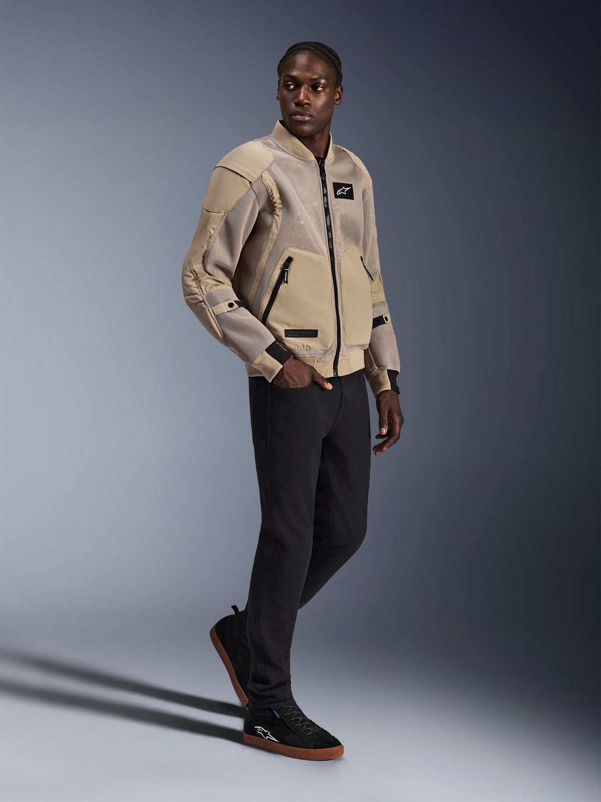 Alpinestars Flight Air Jacket, giacca da moto urbana, colore Alluminio, indossata da un modello con pantaloni neri e sneakers nere, dotata di pannelli di ventilazione in mesh 3D e design in stile bomber, stile street moderno per la guida urbana.