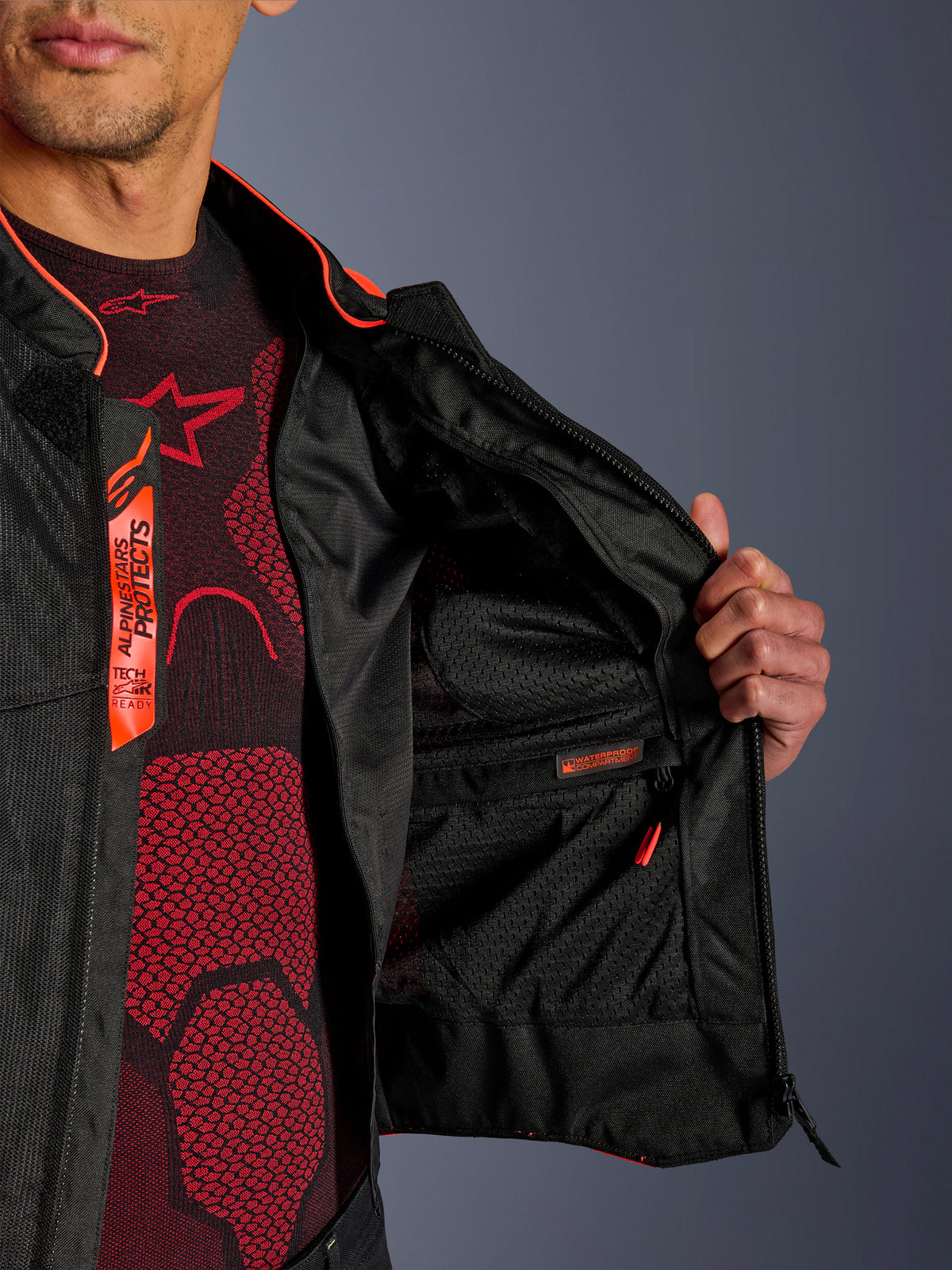 Dettaglio interno della giacca Alpinestars Viper Air V4, mostra lo scomparto interno impermeabile e la fodera in rete tecnica traspirante, accenti Red Fluo e nero con branding Tech-Air Ready
