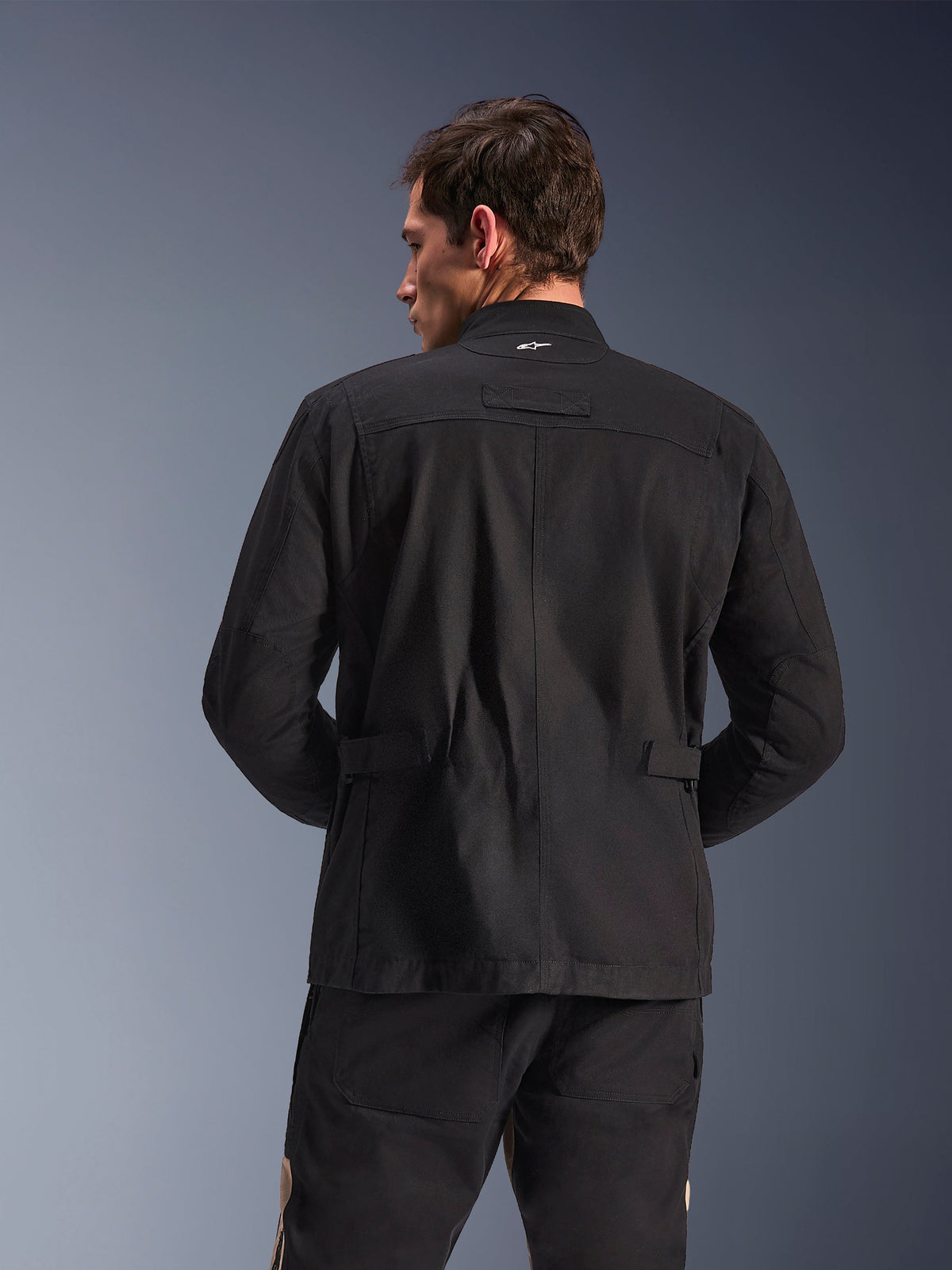 Alpinestars Dice Jacket, giacca da moto urbana, nero, vista posteriore con spalle plissettate e regolazioni in vita, estetica field jacket con piccolo logo bianco sul colletto, abbigliamento tecnico protettivo per la guida in città