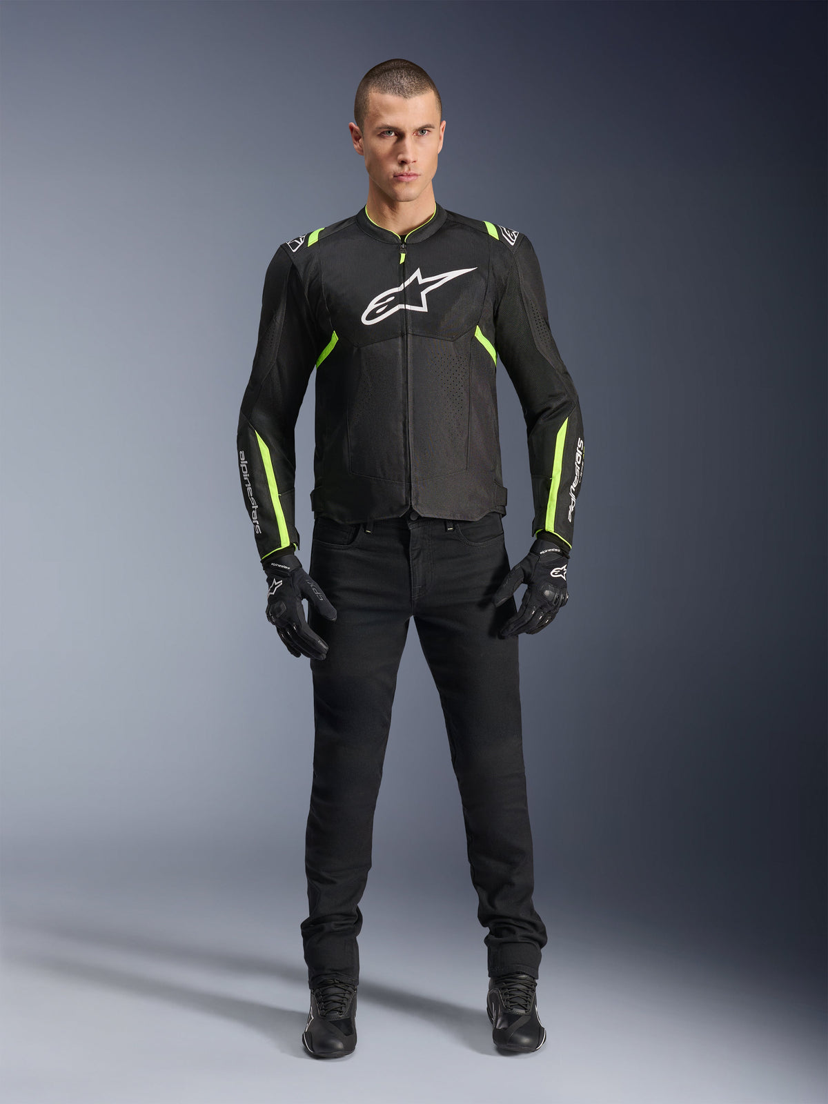 Giacca Alpinestars T-Sps Air V2, nero e giallo fluo, giacca da moto in tessuto con pannelli in rete, indossata da un modello uomo con pantaloni e guanti neri, con logo Alpinestars bianco sul petto, abbigliamento da moto urban sport