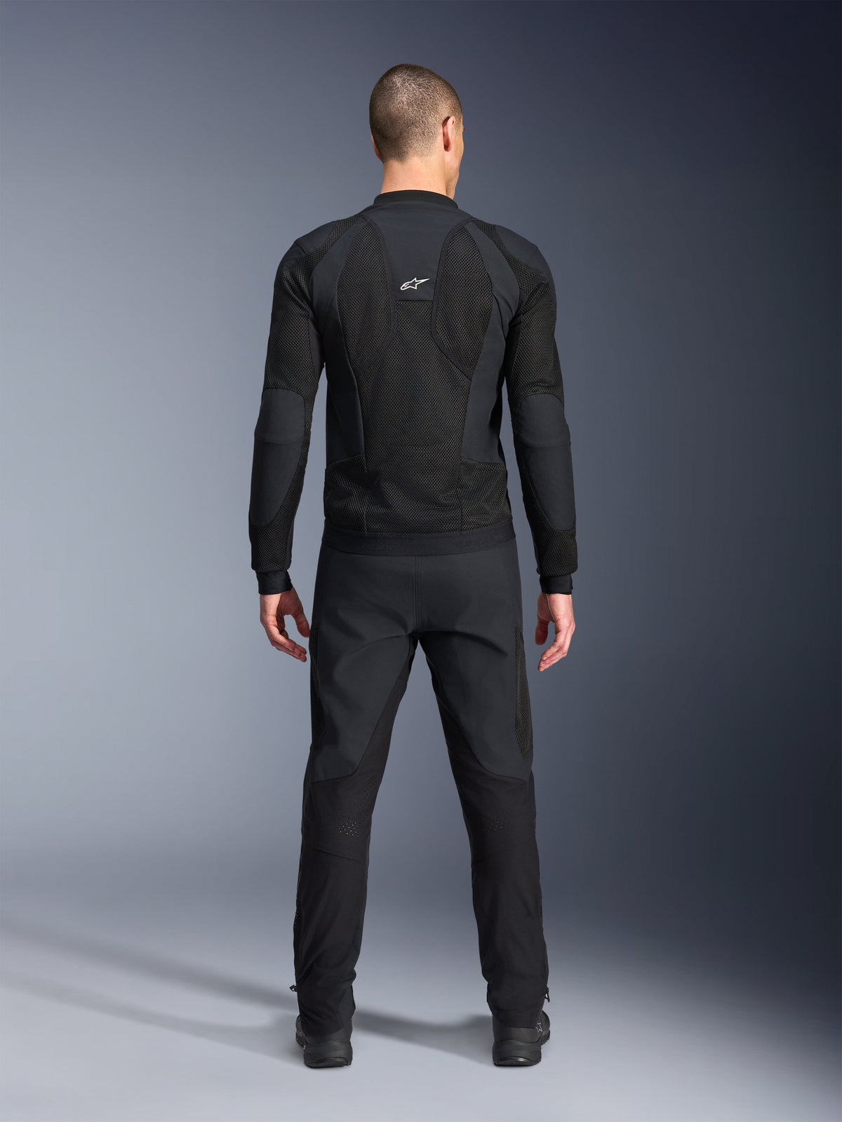 Giacca Alpinestars Troop-Air Pro, vista posteriore, nero, giacca tecnica da moto ventilata con ampi pannelli di ventilazione in mesh e logo Alpinestars bianco, abbinata a pantaloni neri, abbigliamento da moto urban contemporary