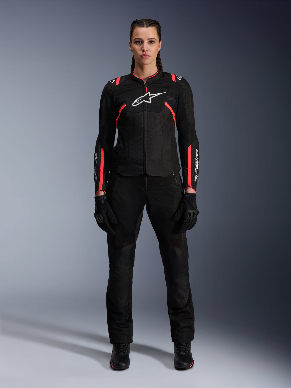 Giacca Alpinestars Stella T-SPS Air v2, giacca da moto da donna, nero e rosa Diva Pink, vista frontale, logo bianco sul petto, pannelli di ventilazione in mesh, indossata con pantaloni e guanti neri, abbigliamento tecnico per guida urbana